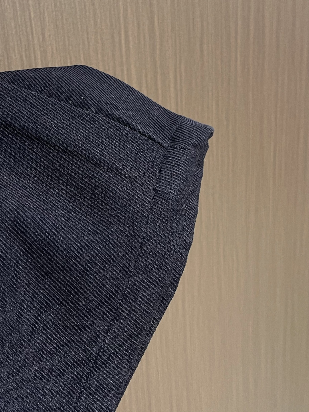 Loewe 皮牌休闲裤，定制丝光雾面羊毛，以雾感深海军蓝为主色调，腰头正面饰有LOE 压纹皮革贴片，与纽