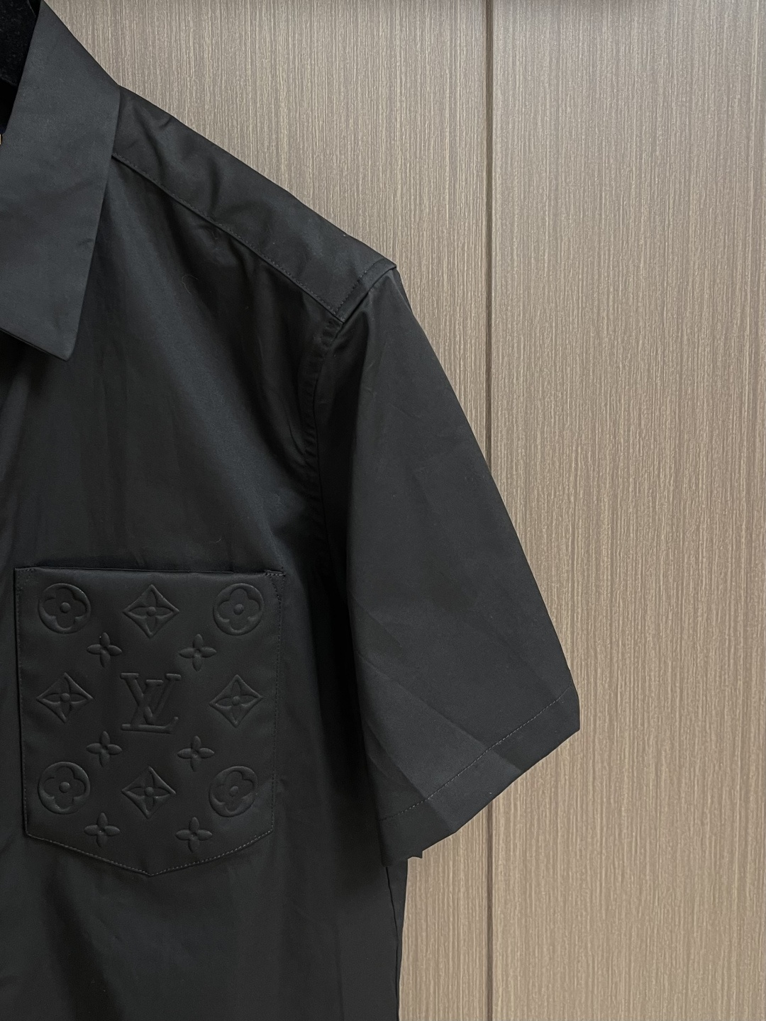 LV 压花口袋翻领短袖衬衫，织物正面斜纹纹路明显，反面比较模糊。经纬向均用单纱，线密度接近，织物经密略高