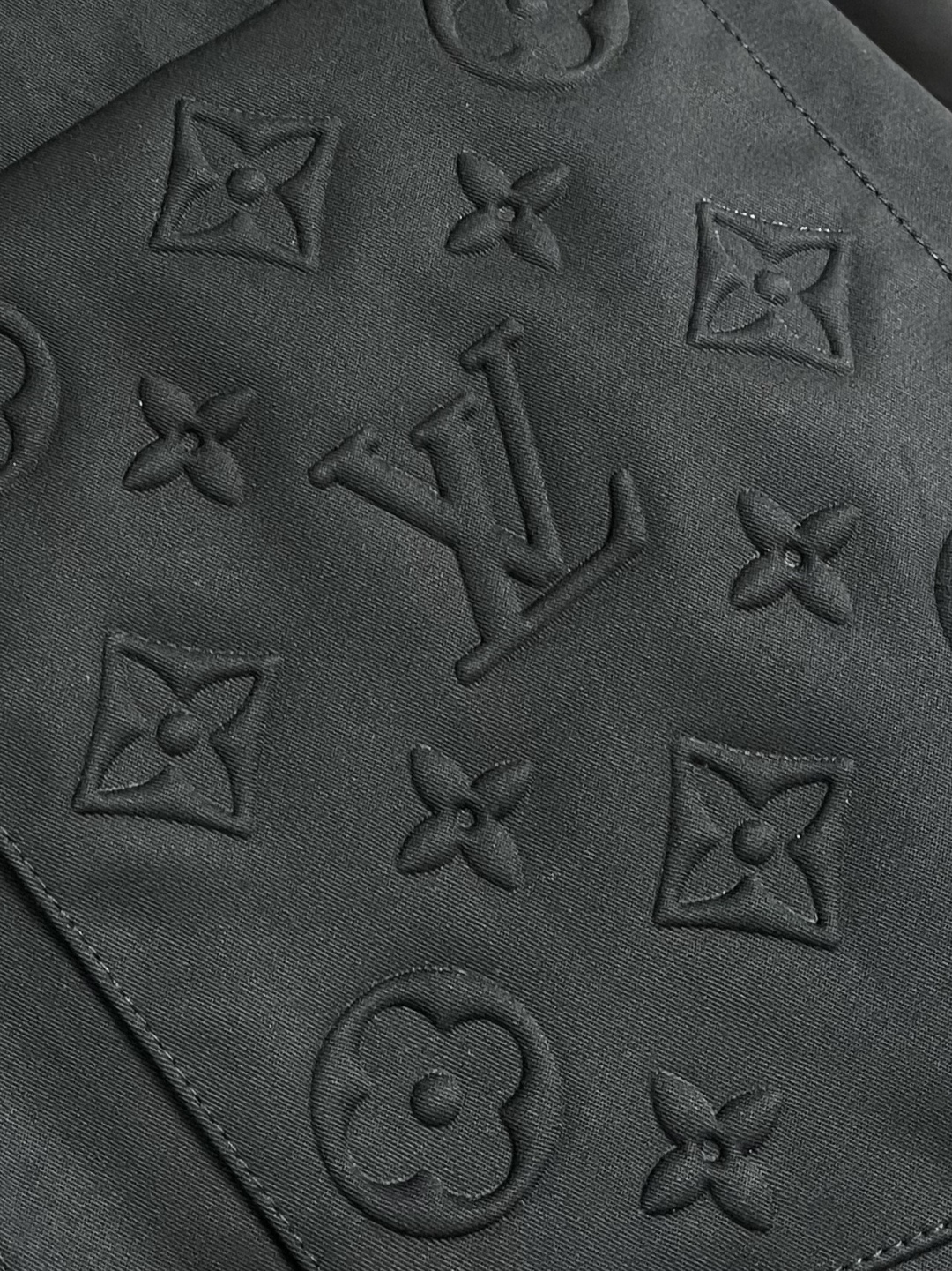 LV 压花口袋翻领短袖衬衫，织物正面斜纹纹路明显，反面比较模糊。经纬向均用单纱，线密度接近，织物经密略高