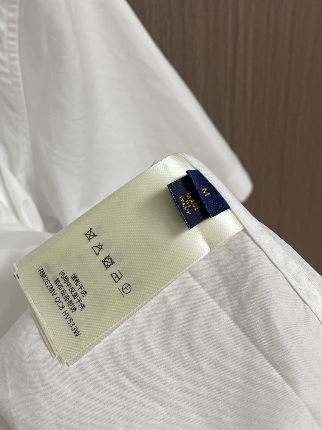 LV 压花口袋翻领短袖衬衫，织物正面斜纹纹路明显，反面比较模糊。经纬向均用单纱，线密度接近，织物经密略高