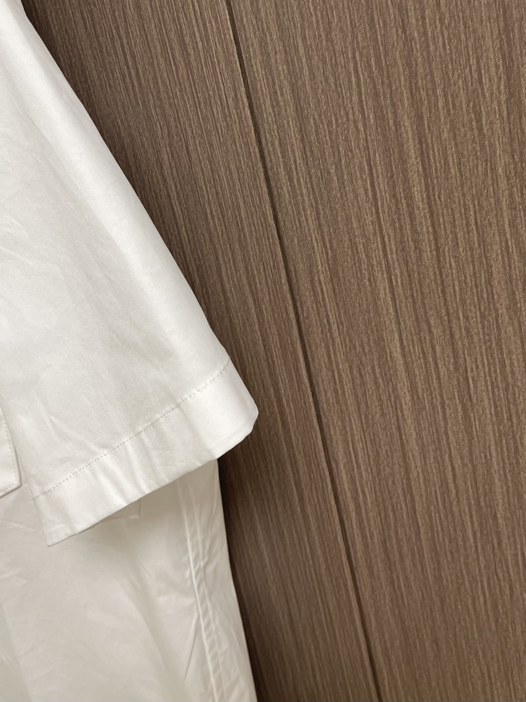 LV 压花口袋翻领短袖衬衫，织物正面斜纹纹路明显，反面比较模糊。经纬向均用单纱，线密度接近，织物经密略高