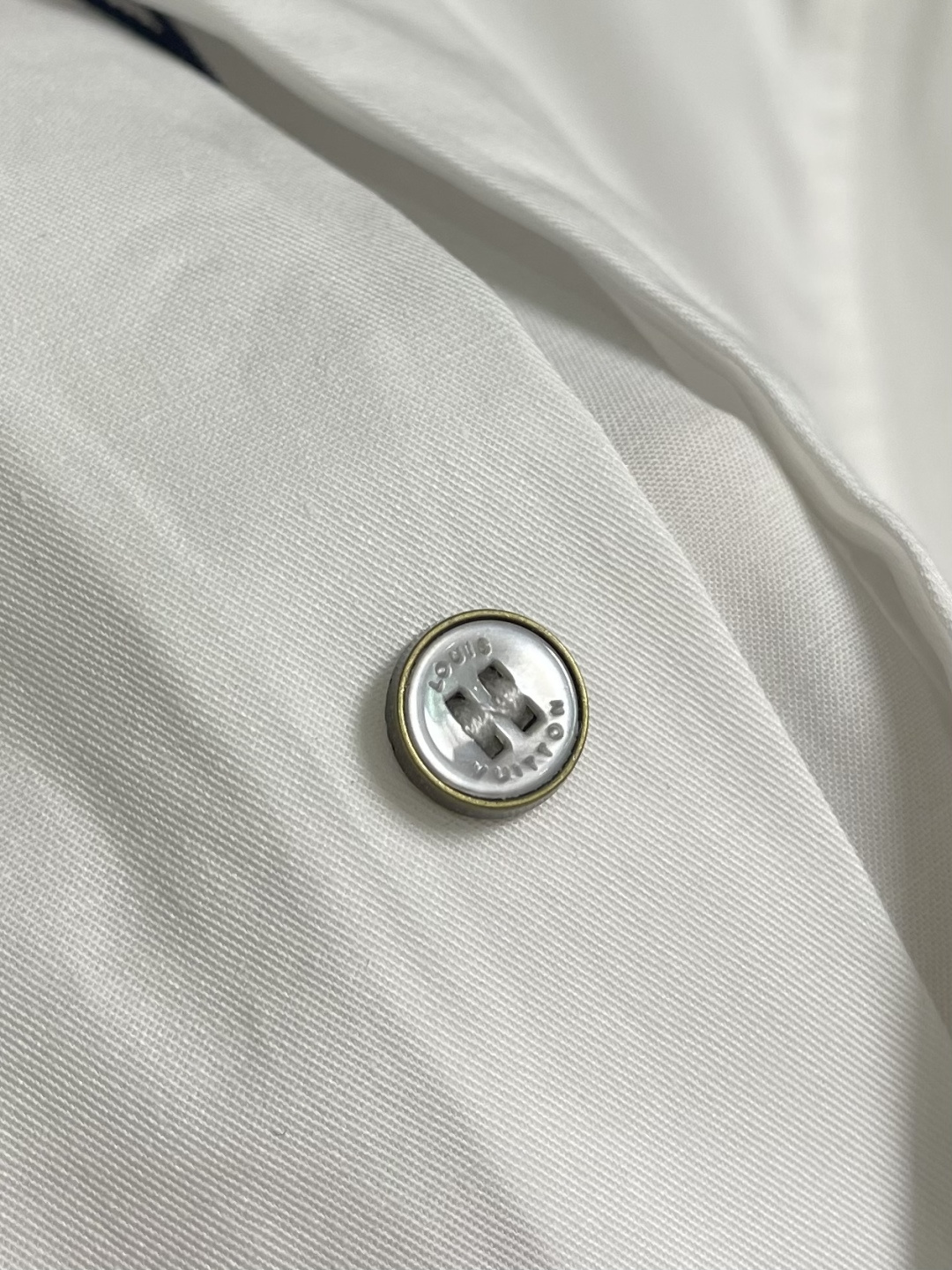 LV 压花口袋翻领短袖衬衫，织物正面斜纹纹路明显，反面比较模糊。经纬向均用单纱，线密度接近，织物经密略高