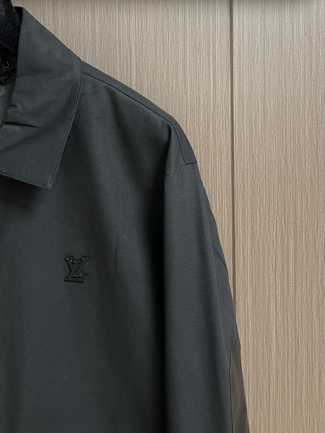 LV 棉质衬衫领拉链贴袋徽标长袖工装外套，这款翻领夹克采用高密度肌理感面料，触感挺括耐磨且兼具垂坠质感，