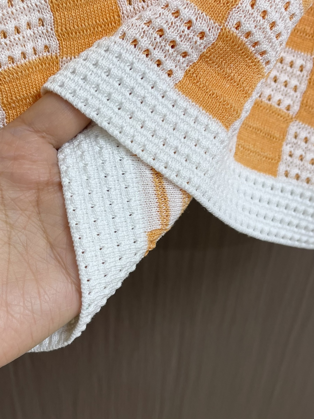 LV 橙白棋盘格肌理针织开衫，采用镂空针织工艺打造橙白棋盘格肌理，经典领搭配撞色罗纹包边，领部与袖口以白