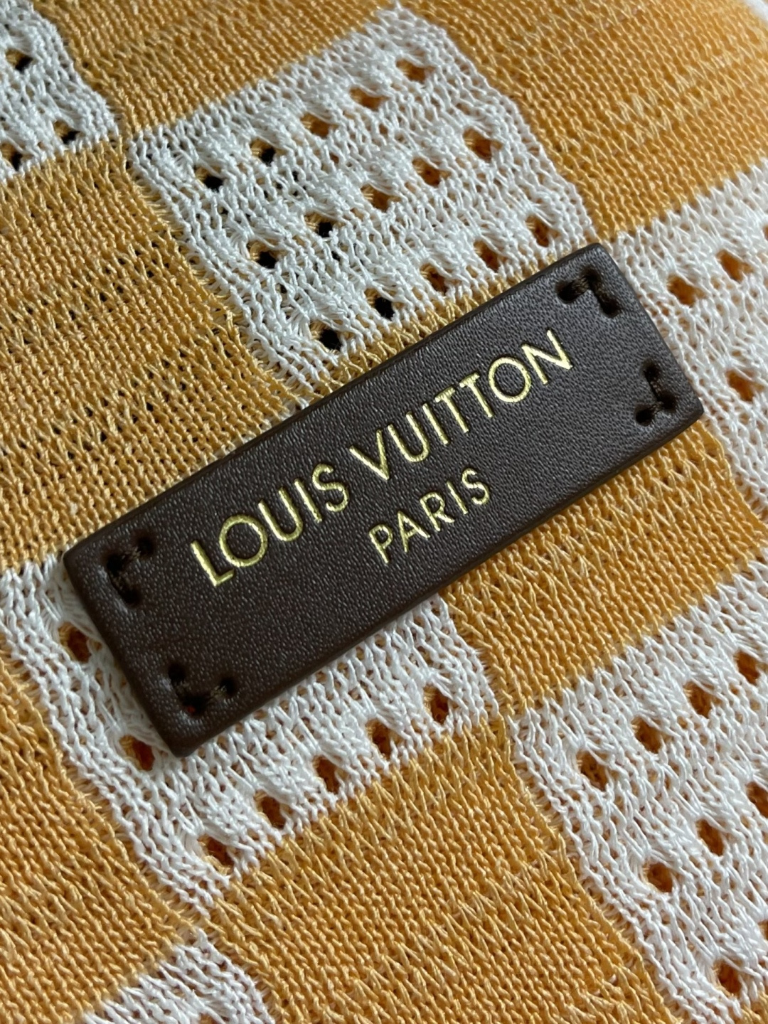 LV 橙白棋盘格肌理针织开衫，采用镂空针织工艺打造橙白棋盘格肌理，经典领搭配撞色罗纹包边，领部与袖口以白