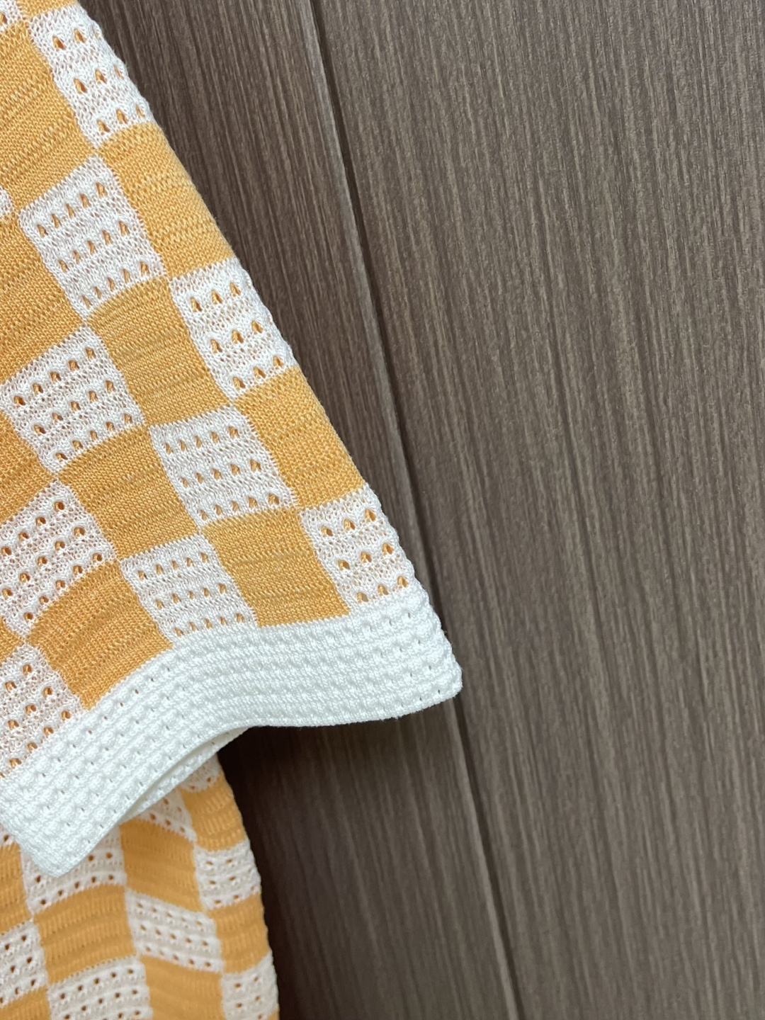 LV 橙白棋盘格肌理针织开衫，采用镂空针织工艺打造橙白棋盘格肌理，经典领搭配撞色罗纹包边，领部与袖口以白