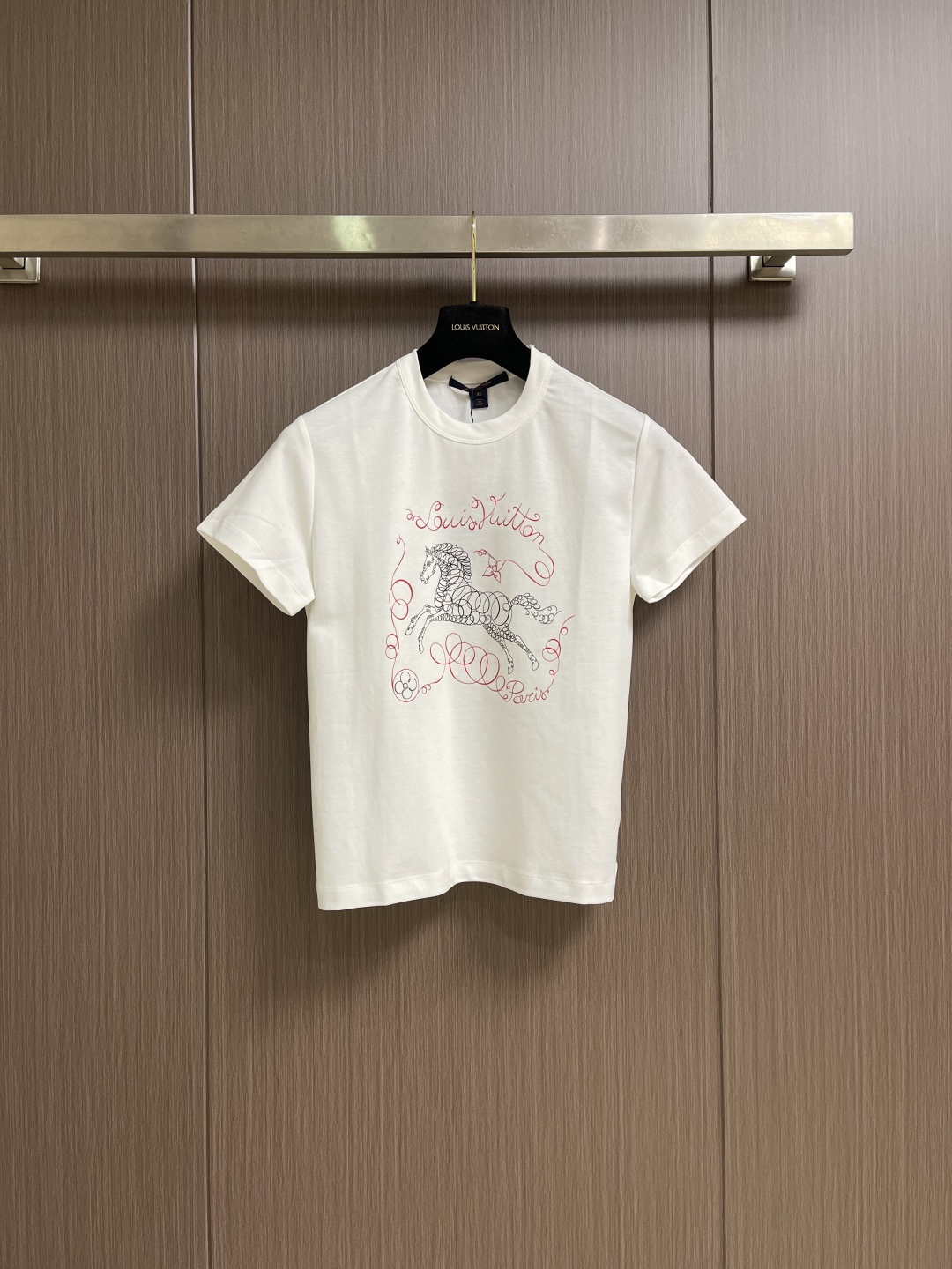 NO:829094,LV  2026ss new spring and summer short-sleeved T-shirt with horse print logo. This white round-neck short-sleeved shirt is made of 230g heavy double-ply Xinjiang long-staple cotton fabric. It is treated with ammonia preshrinking and mercerized singeing. It has a crisp texture and skin-friendly texture.  It is breathable. The neckline is made of high-elastic rib fabric with three-needle double-thread reinforcement. It is washable and not easy to deform. The body uses seamless tube weaving technology to reduce side seam friction. The core pattern on the front panel is presented with high-precision flat embroidery technology. The black horse outline  The stripes are delicate and smooth, and the red brand's iconic floral letters are outlined with chain embroidery. The stitch density of the overall pattern is even, and there are no burrs or jumpers on the edges. The side seams and hems of the body are made of double-needle overlocking technology, and the threads are neatly routed. Each garment is ironed and shaped and inspected by quality control to ensure that the shape is crisp and the details are exquisite, taking into account the comfort of daily wear and the craftsmanship of high-end clothing. The overall stitching is straight and delicate, the fabric is comfortable and soft, and the colors are consistent and without color difference.  It can be matched with the same style to create a fashionable look, and can be used in various occasions. Customized accessories, complete with three standards, same style for men and women!  Size XS-L19860909LV 2026ss春夏新品骏马印花标识短袖T恤,这件白色圆领短袖采用230g重磅双股新疆长绒棉面料,经氨预缩与丝光烧毛工艺处理,兼具挺括质感与亲肤透气性,领口使用高弹罗纹布配合三本针双线加固,耐洗不易变形,衣身采用无缝筒织工艺减少侧缝摩擦,前幅核心图案以高精密平绣工艺呈现,黑色骏马轮廓线条细腻流畅,红色品牌标识性花体字母以锁链绣工艺勾勒,整体图案针脚密度均匀,边缘无毛边与跳线,衣身侧缝及下摆均采用双针锁边工艺,走线工整,每件成衣均经过整烫定型与品控检验,确保版型挺括、细节精致,兼顾日常穿搭的舒适感与高端服饰的工艺质感.整体走线平直细腻,面料舒适柔软,颜色一致无色差 能与同款搭配营造时尚造型,驾驭各种场合,定制辅料,三标齐全,男女同款！尺码XS-L XS码 胸围95肩宽39.5 衣长57 S码 胸围98肩宽40.5 衣长58 M码 胸围102 肩宽41.5衣长59 L码 胸围106 肩宽42.5 衣长60,,louis vuitton,T-shirt,tees，t-shirt,,Men's clothing