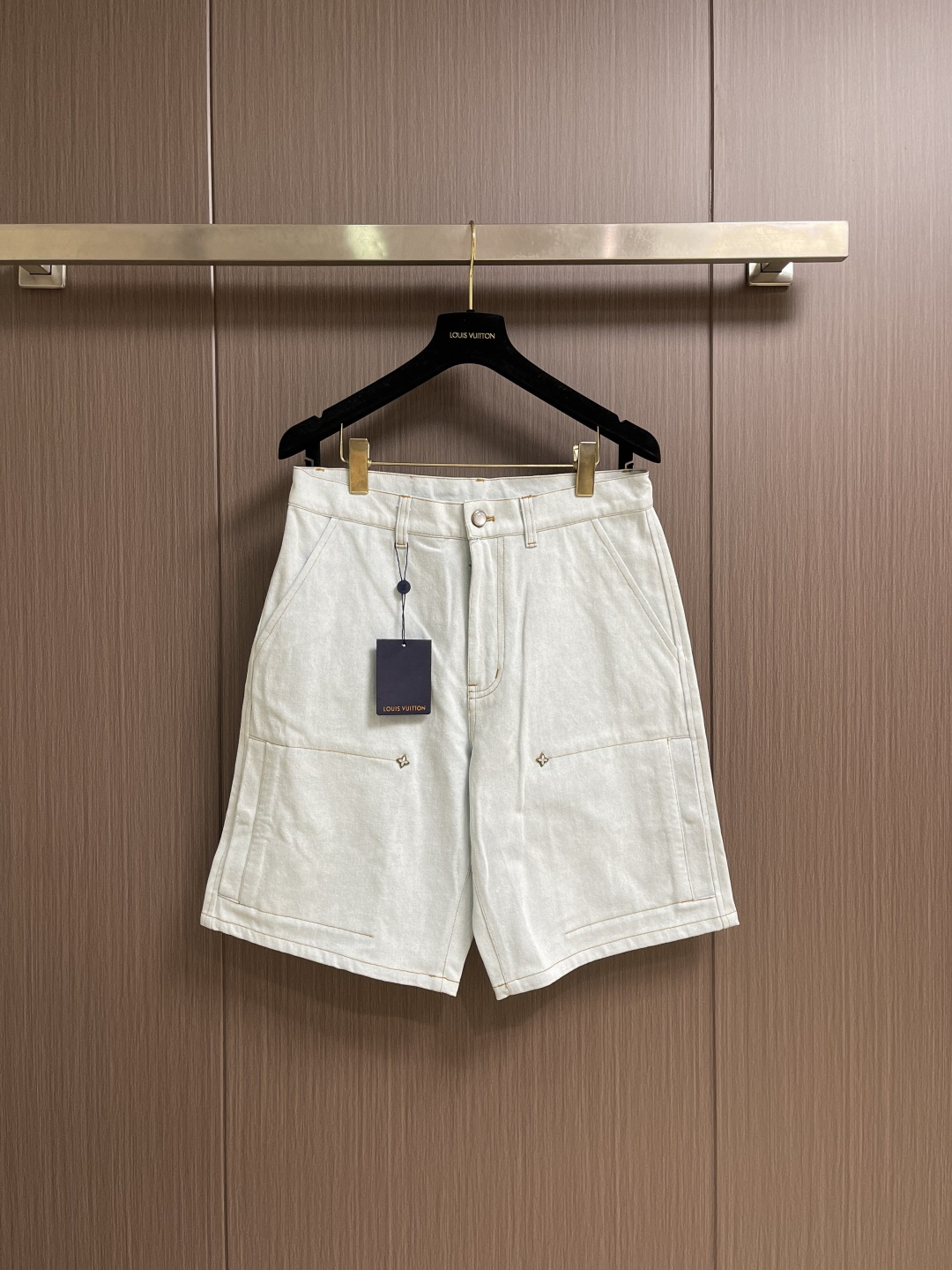 NO:829103,LV The iron flower signature denim shorts are made of slightly whitened twill washed denim fabric, which is a pure cotton twill fabric. The core of the finishing process is the washed and distressed treatment - through stone washing, enzyme washing or light rinsing, the surface of the denim cloth has a natural whitening effect and a soft touch. Stone washing During the washing process, pumice rubs against the fabric to remove part of the indigo dye, forming random local whitening; enzyme washing uses cellulase to gently remove the hairiness on the fiber surface, enhancing the smoothness and softness of the cloth surface. After washing, the fabric shows a slightly white texture, and at the same time The dimensional stability is significantly improved and the subsequent shrinkage is extremely low, ensuring the long-lasting fit of the garment. The back pocket uses chain embroidery technology, which is a stitch method composed of continuous chain-like coils, and the stitches present a continuous chain-like texture. The characteristics of chain embroidery are full stitches, full of three-dimensionality and Elastic, suitable for expressing the smooth curves and elegant strokes of handwritten logos. The leather logo patch on the back needs to be sewn or attached before ironing. Low temperature covering and protection is used during ironing to avoid leather deformation or fading. The overall wiring is straight and delicate, the fabric is comfortable and soft, and the color is consistent without color difference. It can be matched with the same style to create a fashionable look, and can be used in various occasions. Customized accessories, complete with three standards, same style for men and women! Size S-XL 29-30-31-32 Counter sizes are too large 29 yards, pants length 53, waist 83 hips 108, 30 yards, pants length 54, waist 87 hips 112, 31 yards, pants length 55, waist 91 hips 116, 32 yards, pants length 56, waist 95 hips 120,, louis vuitton, shorts,19860909LV 铁花签名牛仔短裤,采用微微泛白的斜纹水洗丹宁布,属于纯棉质斜纹面料.整理工艺的核心在于水洗做旧处理﹣﹣通过石洗、酵素洗或轻漂洗等工序,使丹宁布表面产生自然的泛白效果与柔软触感.石洗过程中,浮石与面料摩擦,去除部分靛蓝染料,形成随机的局部泛白；酵素洗则利用纤维素酶温和去除纤维表面的毛羽,增强布面的光洁度与柔软度.经水洗处理后,面料呈现出微微泛白的质感,同时尺寸稳定性显著提升,后续缩水率极低,保证了成衣的持久合身.后袋采用锁链刺绣工艺,这是一种由链状线圈连续构成的针法,线迹呈现连续的锁链状纹理.锁链刺绣的特点是线迹饱满、富有立体感与弹性,适合表现手写体标识的流畅曲线与优雅笔触.后侧的皮革标识贴饰需在整烫前完成缝制或贴合,整烫时采用低温覆盖保护,避免皮革变形或褪色.整体走线平直细腻,面料舒适柔软,颜色一致无色差 能与同款搭配营造时尚造型,驾驭各种场合,定制辅料,三标齐全,男女同款！尺码S-XL 29-30-31-32 专柜码数偏大 29码 裤长53 腰围83臀围108 30码 裤长54 腰围87臀围112 31码裤长55 腰围91臀围116 32码 裤长56 腰围95臀围120,,louis vuitton,shorts,,Men's clothing