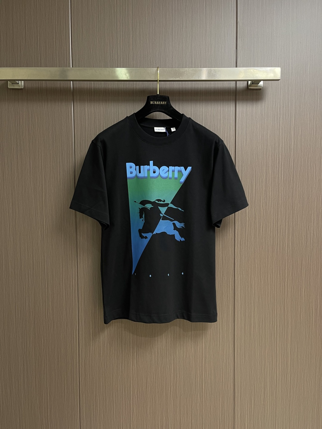 NO:836124,Burberry  Gradient inverted triangle round neck short-sleeved T-shirt, made of 15-count special-spun compact cotton, 230g㎡; paired with 32-count 1×1 rib, 340g㎡. The fabric is a heavy-gauge fabric with strong texture and crisp texture. Because the 15-count yarn is thicker, the shaping process is particularly important.  It can eliminate the internal stress generated during the weaving process of thick yarns and prevent pattern misalignment due to fabric shrinkage during subsequent multi-layer printing. The collar is a high-density tight rib made of cotton. The cotton rib is elastic through high-density weaving and has a more pure and natural touch. The two-color equestrian knight logo and  The brand logo adopts three superposition processes of penetration printing + thick plate printing + suede printing, so that the logo has the delicate gradient of penetration printing, the three-dimensional outline of thick plate printing, and the rich tactile layers of suede printing. As the bottom layer, the water-based slurry penetrates into the fiber to form a pattern.  The basic contours and color levels of the pattern present a watercolor-like blooming effect, with a soft and glue-free feel. Stacked printing in specific areas creates a raised three-dimensional relief feeling. Through repeated printing many times, the slurry is accumulated to the point. The overall wiring is straight and delicate, the fabric is comfortable and soft, and the colors are consistent and without color difference.  It can be matched with the same style to create a fashionable look, and can be used in various occasions. Customized accessories, complete with three standards, same style for men and women!  Size XS-L19860909Burberry 渐变倒三角圆领短袖T恤,用15支特纺紧密棉,230g㎡；搭配32支1×1罗纹,340g㎡.面料属于粗针重克重面料,肌理感强、质地挺括.由于15支纱线较粗,定形工序尤为重要,它能消除粗支纱线织造过程中产生的内应力,防止后续多层印花时因面料收缩导致图案错位.衣领属于全棉高密度紧实罗纹,全棉罗纹通过高密度织造实现弹性,触感更加纯粹自然.双色马术骑士徽标和品牌徽标采用渗透印花+厚板印花+绒面印花三种工艺叠加,使徽标既有渗透印花的细腻渐变,又有厚板印花的立体轮廓,还有绒面印花的丰富触觉层次.作为底层水性浆料渗透至纤维内部,形成图案的基础轮廓与色彩层次,呈现类似水彩的晕染效果,且手感柔软无胶感在特定区域堆叠印出凸起的立体浮雕感,通过多次重复印刷使浆料堆积至.整体走线平直细腻,面料舒适柔软,颜色一致无色差 能与同款搭配营造时尚造型,驾驭各种场合,定制辅料,三标齐全,男女同款！尺码XS-L XS码胸围102肩宽46.5衣长71 S码 胸围106肩宽48衣长73 M码胸围110 肩宽49.5衣长75 L码 胸围114 肩宽51衣长77,,burberry,T-shirt,tees，t-shirt,,Men's clothing