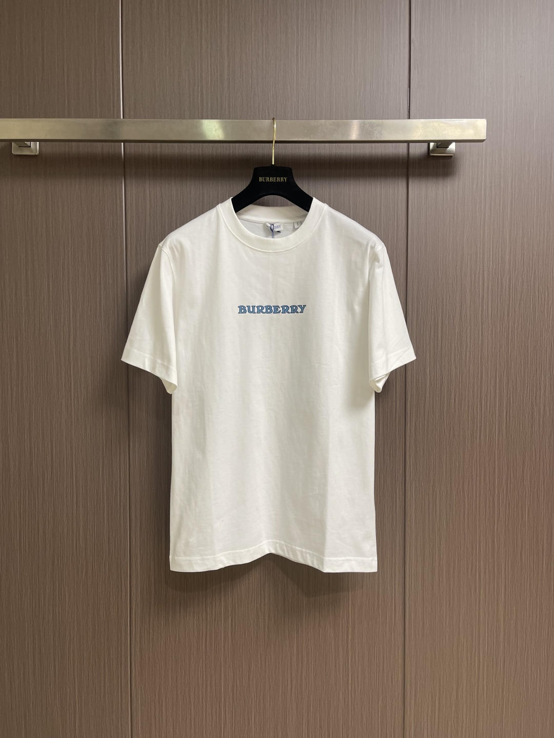NO:845210,Burberry  The Blue Knight round-neck short-sleeved T-shirt is made of 15-count special-spun compact cotton, 230g㎡; with 32-count 1×1 rib, 340g㎡. The fabric is a heavy-weight fabric with thick needles, strong texture, and crisp texture. Because the 15-count yarn is thicker, the shaping process is particularly important. It can eliminate the internal stress generated during the weaving process of the thick-count yarn and prevent pattern misalignment due to fabric shrinkage during subsequent multi-layer printing. The collar is high-density cotton  Highly compact rib, cotton rib achieves elasticity through high-density weaving, and the touch is more pure and natural. The collection logo and the equestrian knight logo use a thick plate pulp process. The printing is repeatedly superimposed and printed on the same pattern area through a silk screen. Multiple layers of glue are printed repeatedly. The difficulty of this process lies in the alignment accuracy and thickness control of each layer. The dried pulp will accumulate on the surface of the fabric to create an obvious relief texture, which feels stiff and has a sharp outline.  .The overall wiring is straight and delicate, the fabric is comfortable and soft, and the color is consistent without color difference. It can be matched with the same style to create a fashionable look and control various occasions. Customized accessories, complete with three standards, same style for men and women!  Sizes XS-L19860909Burberry 蓝骑士圆领短袖T恤,用15支特纺紧密棉,230g㎡；搭配32支1×1罗纹,340g㎡.面料属于粗针重克重面料,肌理感强、质地挺括.由于15支纱线较粗,定形工序尤为重要,它能消除粗支纱线织造过程中产生的内应力,防止后续多层印花时因面料收缩导致图案错位.衣领属于全棉高密度紧实罗纹,全棉罗纹通过高密度织造实现弹性,触感更加纯粹自然.典藏徽标和马术骑士徽标采用的是厚板浆工艺.印花通过丝网在同一个图案区域反复叠加印刷多层胶浆.这一工艺的难点在于每层的对齐精度和对厚度的控制.干燥后的浆料会在面料表面堆积出明显的浮雕质感,手感硬挺且轮廓锐利 .整体走线平直细腻,面料舒适柔软,颜色一致无色差 能与同款搭配营造时尚造型,驾驭各种场合,定制辅料,三标齐全,男女同款！尺码XS-L XS码胸围102肩宽47衣长71 S码 胸围106肩宽48.5衣长73 M码胸围110 肩宽50衣长75 L码 胸围114 肩宽51.5 衣长77,,burberry,T-shirt,tees，t-shirt,,Men's clothing