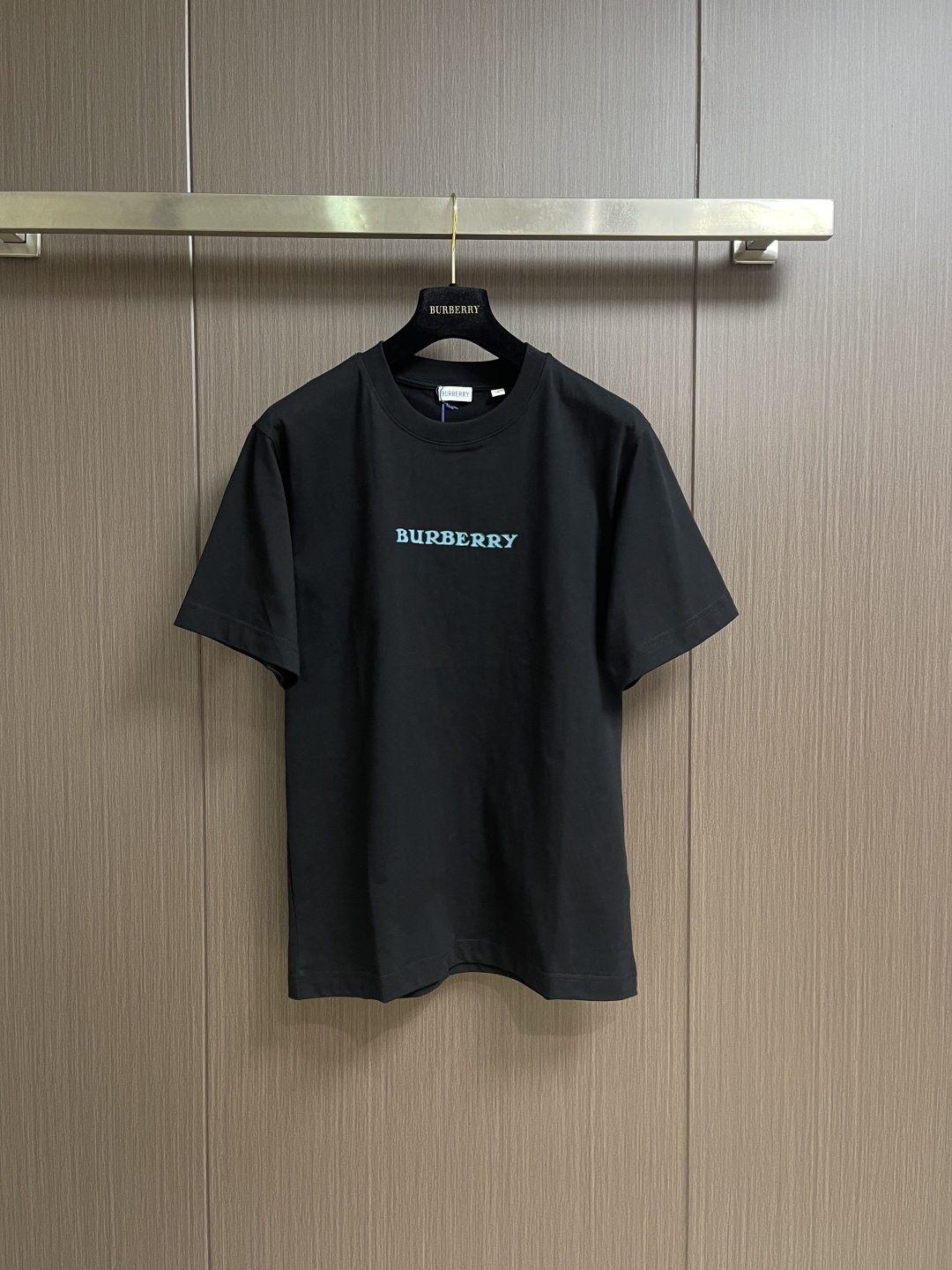 NO:845215,Burberry  The Blue Knight round-neck short-sleeved T-shirt is made of 15-count special-spun compact cotton, 230g㎡; with 32-count 1×1 rib, 340g㎡. The fabric is a heavy-weight fabric with thick needles, strong texture, and crisp texture. Because the 15-count yarn is thicker, the shaping process is particularly important. It can eliminate the internal stress generated during the weaving process of the thick-count yarn and prevent pattern misalignment due to fabric shrinkage during subsequent multi-layer printing. The collar is high-density cotton  Highly compact rib, cotton rib achieves elasticity through high-density weaving, and the touch is more pure and natural. The collection logo and the equestrian knight logo use a thick plate pulp process. The printing is repeatedly superimposed and printed on the same pattern area through a silk screen. Multiple layers of glue are printed repeatedly. The difficulty of this process lies in the alignment accuracy and thickness control of each layer. The dried pulp will accumulate on the surface of the fabric to create an obvious relief texture, which feels stiff and has a sharp outline.  .The overall wiring is straight and delicate, the fabric is comfortable and soft, and the color is consistent without color difference. It can be matched with the same style to create a fashionable look and control various occasions. Customized accessories, complete with three standards, same style for men and women!  Sizes XS-L19860909Burberry 蓝骑士圆领短袖T恤,用15支特纺紧密棉,230g㎡；搭配32支1×1罗纹,340g㎡.面料属于粗针重克重面料,肌理感强、质地挺括.由于15支纱线较粗,定形工序尤为重要,它能消除粗支纱线织造过程中产生的内应力,防止后续多层印花时因面料收缩导致图案错位.衣领属于全棉高密度紧实罗纹,全棉罗纹通过高密度织造实现弹性,触感更加纯粹自然.典藏徽标和马术骑士徽标采用的是厚板浆工艺.印花通过丝网在同一个图案区域反复叠加印刷多层胶浆.这一工艺的难点在于每层的对齐精度和对厚度的控制.干燥后的浆料会在面料表面堆积出明显的浮雕质感,手感硬挺且轮廓锐利 .整体走线平直细腻,面料舒适柔软,颜色一致无色差 能与同款搭配营造时尚造型,驾驭各种场合,定制辅料,三标齐全,男女同款！尺码XS-L XS码胸围102肩宽47衣长71 S码 胸围106肩宽48.5衣长73 M码胸围110 肩宽50衣长75 L码 胸围114 肩宽51.5 衣长77,,burberry,T-shirt,tees，t-shirt,,Men's clothing