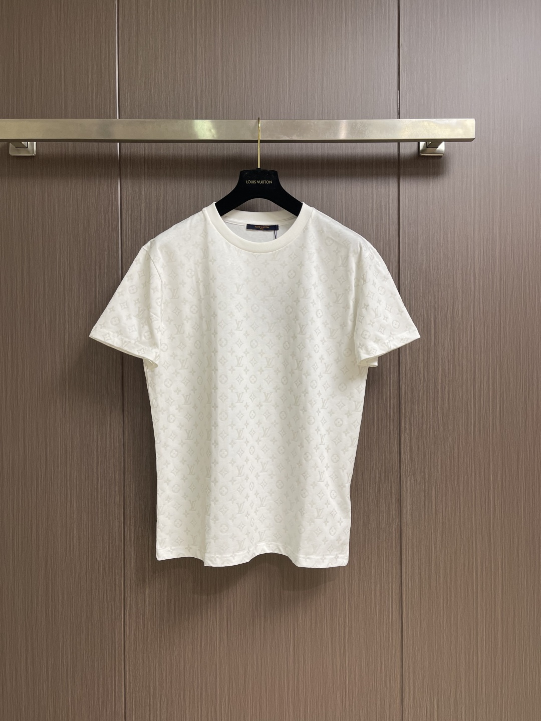 NO:928902,LV  Firefly printed round neck short-sleeved T-shirt is made of 15S special-spun compact cotton with a weight of 230gm. It is matched with 32S1×1 ribbing on the neck and has a weight of up to 340gm. Compact spinning technology can effectively eliminate yarn hairiness, make the yarn body smooth and even, which makes the surface of the fabric appear...  It shows a high-end texture with a slightly matte surface and improves the anti-pilling performance. The fabric is medium-weight and has a drapey feel and a flexible frame. It can naturally fit the body curves and maintain the contour. This high-density, high-weight rib has a tight structure, solid texture, and excellent elasticity and rebound.  It is elastic and can firmly lock the collar. This is the core process of the entire T-shirt. A special paste is printed on the fabric through screen printing. This paste can absorb and reflect light energy when exposed to ultraviolet light, highlighting the unique color of the pattern. Under normal light, the pattern appears  Now it has a same-color effect with consistent tones; when placed in the dark and irradiated by ultraviolet light, the printing energy will be slowly released in the form of shimmer, making the Monogram pattern clearly appear. This process requires the printing slurry to be evenly adhered, and the luminous powder needs to be stable in the slurry  Distribution to ensure long-lasting and uniform luminous effect. The key to ensuring visual uniformity of the all-over pattern. This means that every piece from the body, sleeves to side seams must be strictly aligned with the printed pattern when cutting and sewing. The position of each piece needs to be accurately calculated when laying out;  Single piece cutting is used to ensure accuracy; when sewing, the sewing worker needs to constantly adjust during the sewing process to ensure that the patterns at the shoulder seams, side seams and other splicing areas can be seamlessly connected and the lines run through. Using a standard version design, the shoulder line accurately falls on the acromion point, outlining a clear shoulder outline; the body  It has a straight cut, with similar bust and hem circumferences. It fits well but is not tight, leaving a moderate amount of room for movement. The sleeves are standard short sleeve length, and the cuffs and hem are finely cuffed. The structure is simple and neat. The overall version is neither too loose nor too narrow, providing a perfect fit for the all-over presbyopia pattern.  The flat and complete display area allows the pattern to be evenly laid out on the chest, back and sleeves to avoid excessive deformation of the pattern that may affect the visual effect of the printing, while ensuring the comfort and versatility of daily wear. The overall routing is straight and delicate, the fabric is comfortable and soft, and the colors are consistent and without color difference.  Can be matched with the same style to create a fashionable look, to suit various occasions, customized accessories, complete with three standards!  Size SML19860909LV 荧火虫印花圆领短袖T恤,选用15S特纺紧密棉,克重为230gm；搭配领口32S1×1罗纹,克重高达340gm.紧密纺技术能有效消除纱线毛羽,使纱体光洁、条干均匀,这让面料表面呈现出微雾面的高级质感,并提升了抗起毛球性能.面料中克重,兼具了垂坠感与柔韧的骨架；能自然地贴合身体曲线,保持轮廓.这种高密度、高克重的罗纹结构紧密、质地扎实,具有极佳的弹力和回弹性,能牢牢锁住领圈.这是整件T恤最核心的工艺,通过丝网印刷将含有特殊浆料印制在面料上.这种浆料在紫外光照射时能吸收并光能进行反射作用,凸显出图案独有色彩.在正常光线下,图案呈现为色调一致的同色系效果；当置于黑暗中经紫外线灯照射时,印花的能量便会以微光的形式缓慢释放,使Monogram图案清晰显现.该工艺要求印花浆料能均匀附着,且夜光粉需在浆料中稳定分布,以确保发光效果持久均匀.确保通体图案视觉统一的关键.这意味着从大身、袖子到侧缝的每一片裁片,在裁剪和缝制时都必须严格对齐印花图案.排料时需精确计算每片裁片的位置；裁剪时多采用单片裁剪以保证精度；缝制时,缝纫工需在车缝过程中不断调整,确保肩缝、侧缝等拼接处的图案能无缝连接、纹路贯通.采用标准版型设计,肩线精准落在肩峰点,勾勒出清晰的肩部轮廓；衣身呈直筒剪裁,胸围与下摆围度相近,合身而不紧身,留有适度活动空间.袖型为标准短袖长度,袖口与下摆均采用精细收口,结构简洁利落.整体版型不过分宽松也不过分收窄,为通体老花图案提供了平整完整的展示区域,图案得以均匀铺陈于前胸、后背及袖面,避免因版型过度变形而影响印花视觉效果,同时确保日常穿着的舒适性与搭配普适性.整体走线平直细腻,面料舒适柔软,颜色一致无色差 能与同款搭配营造时尚造型,驾驭各种场合,定制辅料,三标齐全！尺码SMLXL S码 衣长68　 胸围108　 肩宽38 M码 衣长70　 胸围112　 肩宽40 L码 衣长72　 胸围116　 肩宽42 XL码衣长74　 胸围120　 肩宽44,,louis vuitton,T-shirt,tees，t-shirt,,Men's clothing