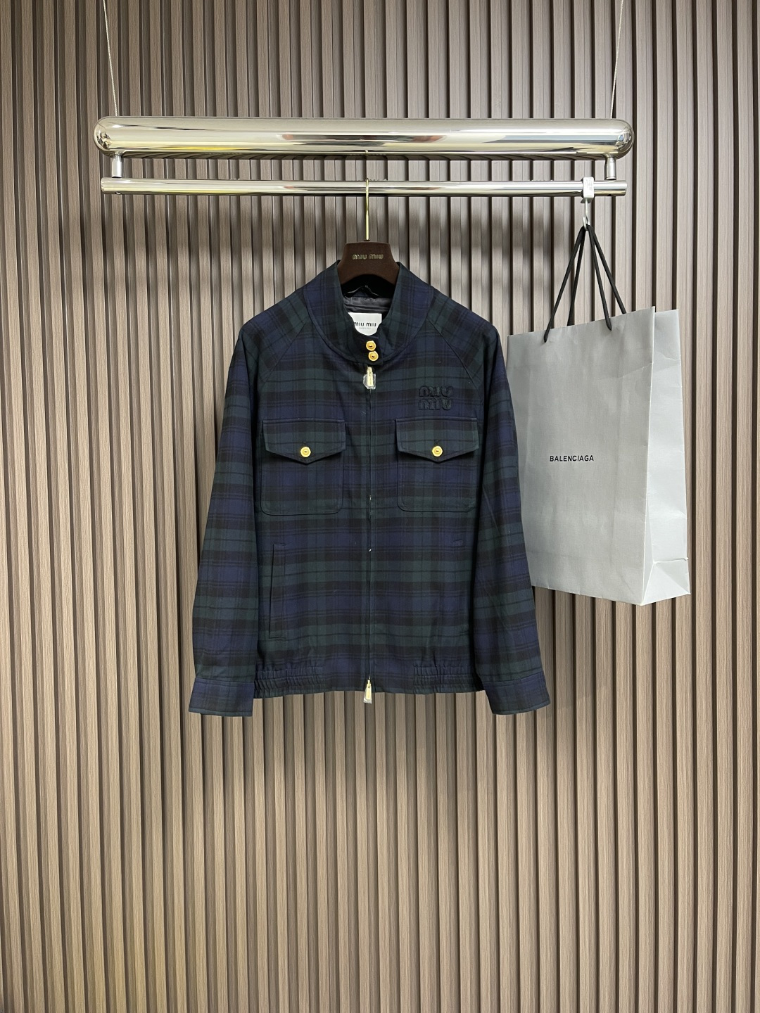 NO:120256,miumiu  Wool checked jacket, fabric selection and color spinning process use customized wool color spinning houndstooth fabric. The color spinning process allows the colors to be evenly distributed in the yarn, which not only enhances the texture of the fabric, but also ensures the firmness of the color and the difficulty of fading. Accurate cutting and positioning cutting bed uses positioning and cutting bed equipment to accurately cut the fabric, improves the overall quality through optical positioning and mechanical positioning, ensuring that every product meets the high standards of miumiu. Embroidery logo and Tashima embroidery machine  Use Tajima embroidery machine to apply fabrics of various shapes to the basic fabric, and then use embroidery thread to lock and decorate them, making the embroidered logo more firm and beautiful, highlighting the brand style. Details are cleverly spliced ​​with plaid fabrics of the same color at the details such as the cuffs and hem, with rich layers; the stand collar and button cuff design are both practical and beautiful; the patch pocket design is convenient to carry small items, and it also adds the practicality of the jacket. Size 46-52,,miumiu, jackets  & coats,alexander wang19860909miumiu 羊毛格纹夹克,面料选择与色纺工艺采用定制羊毛色纺千鸟格面料,色纺工艺使颜色均匀地分布在纱线中,不仅提升了面料的质感,还确保了色彩的牢固度和不易褪色性.精准裁剪与定位裁床使用定位裁床设备进行精准裁剪布料,通过光学定位和机械定位提高整体质量,确保每一件产品都符合miumiu的高标准.刺绣徽标与田岛绣花机运用田岛绣花机将各种形状的布料贴合在基础布料上,再用绣线进行锁边和装饰,使刺绣徽标更加牢固且美观,彰显品牌格调.细节处理在袖口与下摆等细节处巧妙拼接同色系格子面料,层次丰富；立领与纽扣袖口设计既实用又美观；贴袋设计方便携带小物品,同时增添了夹克的实用性.尺码46-52,,miumiu,jackets & coats,alexander wang,Men's clothing