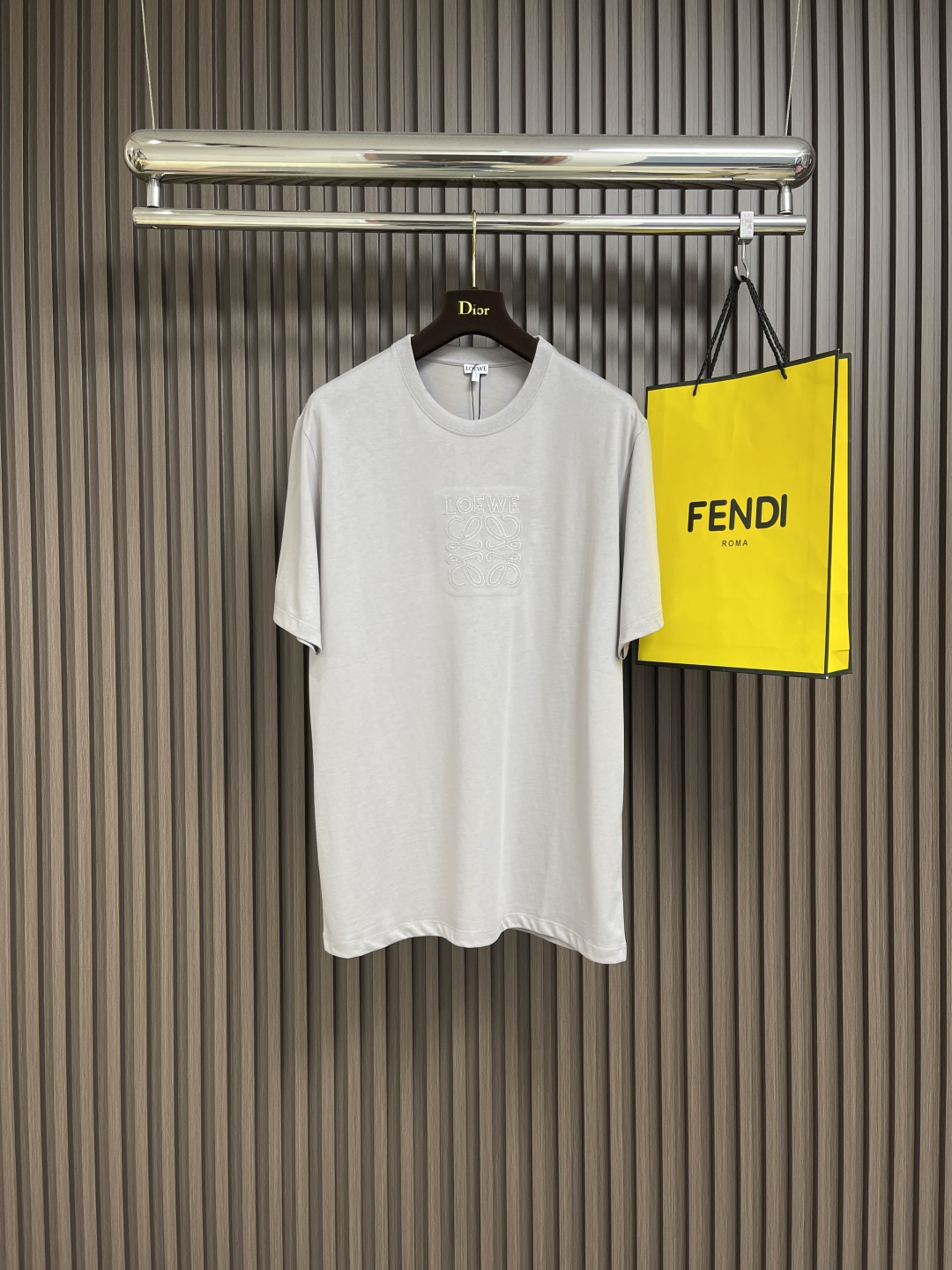 NO:130344,loewe serrated thread patch short-sleeved T-shirt, using 15s fine cotton plain pattern, 230g; matched with 32s double yarn thread, 340g. The edges of the patch embroidery strengthen branches, and by imitating the serrated shape, it increases the rough industrial vision. The patch embroidery serrated serrated, shaped like canine teeth intertwined; emphasizes the high density of the stitches and sharp twists, such as saw blade cutting traces. The trimming seams cut off excess fabric along the dog floss stitches, retaining the three-dimensional sense of serrated serrated. The overall thread is straight and delicate, the fabric is comfortable and soft, and the color is consistent and has no color difference. It can be matched with the same style to create a fashionable shape, control various occasions, customize auxiliary materials, complete three standards, and the same style for men and women!  Size XS-L, loewe, T-shirt,tees, t-shirt,alexander wang19860909loewe 锯齿线贴布短袖T恤,采用15s精棉平纹,230g；搭配32s双纱拉架螺纹,340g.贴布绣的边缘强化分支,通过模仿锯齿形态的线迹,增加粗犷工业风视觉.贴布绣线迹呈梯形锯齿,形似犬齿交错；强调线迹密度高、转折锋利,如锯条切割痕迹.修剪缝份沿狗牙线迹剪去多余布料,保留锯齿立体感.整体走线平直细腻,面料舒适柔软,颜色一致无色差 能与同款搭配营造时尚造型,驾驭各种场合,定制辅料,三标齐全,男女同款！尺码XS-L,,loewe,T-shirt,tees，t-shirt,alexander wang,Men's clothing