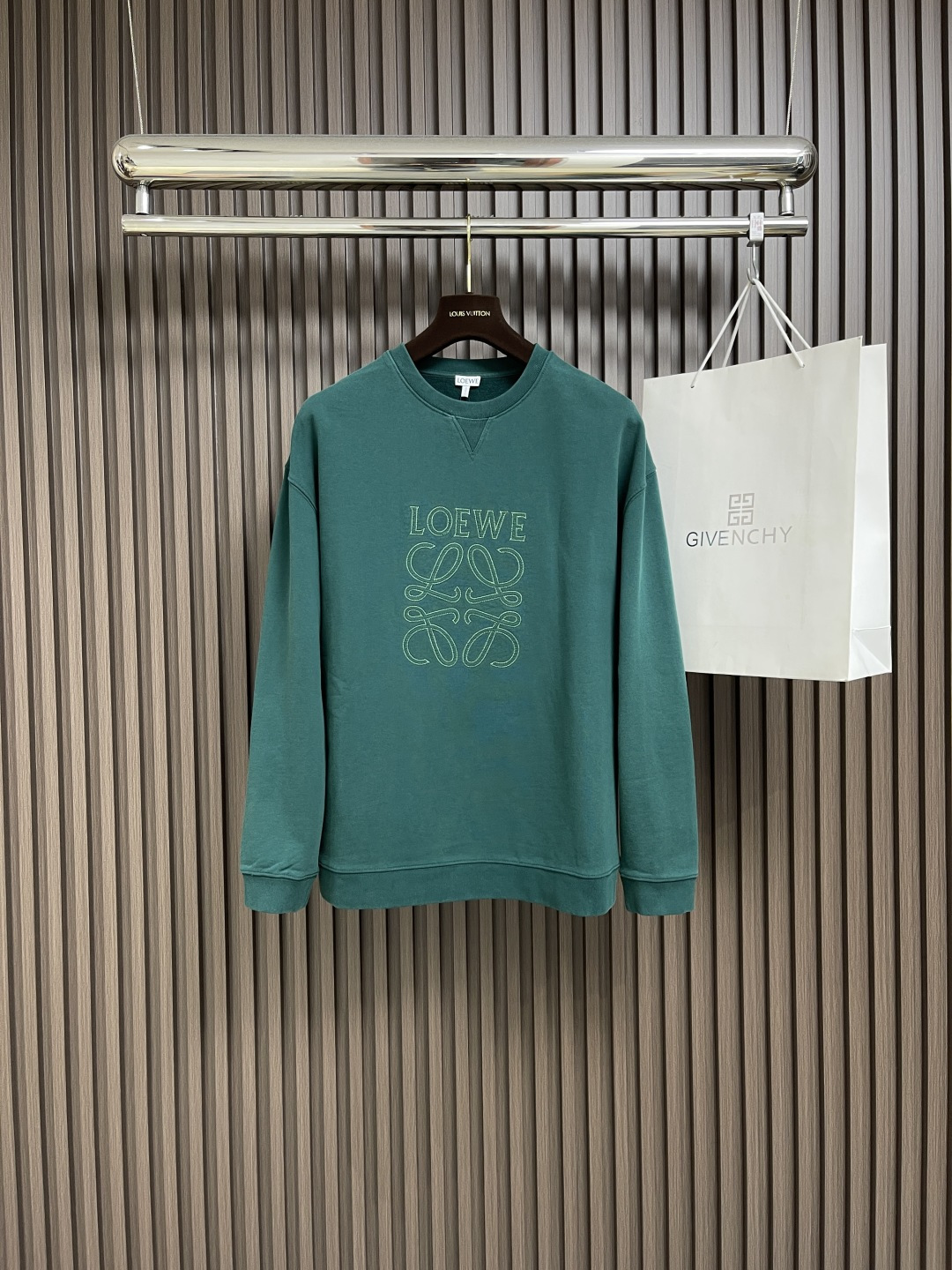 NO:132981,loewe  Contrast line patch embroidered round-neck sweatshirt, medium-grain heavy cotton loop fleece fabric, using 16s single yarn   10s single yarn fish scale fixed sweatshirt fabric, 380g. The chest is decorated with laser cutting applique, and the edges of patch embroidery strengthen branches. By imitating the serrated shape, it increases the rough industrial vision. The patch embroidery stitches are trapezoidal serrated, shaped like canine teeth interlaced; emphasize high density of stitches and sharp twists, such as saw blade cutting traces. Cut off excess fabric along the stitches, retaining the three-dimensional sense of serrated serrated. The sand and old process are made after the garment are fried, and the color process is made by dyeing and dyeing, washing and old. The fabric is dyed and processed by stone milling, and the garment is constantly immersed in  Rolling in the dye. The fabric fades slightly after stir-frying sand, changing the color of the original fabric to show nostalgic colors of different shades and light and darkness. The front v-shaped details, and the neckline adopts a structural feature formed by the rib weaving method of V-shaped arrangement, which has a unique visual sense of line and extension. The rib structure itself has good elasticity and elasticity; the seams of the shoulder thread are inserted into the seams to increase the service life. The neckline, hem, and cuffs are spliced ​​with thread threads of the gantry, and the large body and sleeve tube are structurally divided into honed seams. The fabric material has a ductility and unrestrained sense. Size XS-L,,loewe, hoodie, sweatshirts, alexander  wang19860909loewe 撞色线贴布刺绣圆领卫衣,中克重棉质回圈抓绒面料,采用16s单纱＋10s单纱鱼鳞定卫衣面料,380g.胸前饰有激光切割贴花,贴布绣的边缘强化分支,通过模仿锯齿形态的线迹,增加粗犷工业风视觉.贴布绣线迹呈梯形锯齿,形似犬齿交错；强调线迹密度高、转折锋利,如锯条切割痕迹.修剪缝份沿线迹剪去多余布料,保留锯齿立体感.炒砂做旧工艺,成衣后进行炒色工艺制作而成,成衣环保新工艺转染染色、洗水做旧.通过石磨的方式对面料进行染色加工,成衣不断地浸入染料中翻滚.炒砂后面料轻微掉色效果,改变原面料颜色呈现出深浅一明暗不同的怀旧色彩.正面v形细节,领口采用v形排列的罗纹编织方式所形成的一种结构特点,在视觉上具有独特的线条感和延伸性.罗纹结构本身具有较好的弹性和伸缩性；肩线做缝处均内加嵌条,增加使用寿命.领口、下摆、袖口均以坎车双针车线螺纹拼接,大身及袖管结构性切分珩缝,面料材质具有的延展性无约束感.尺码XS-L,,loewe,hoodie,sweatshirts,alexander wang,Men's clothing