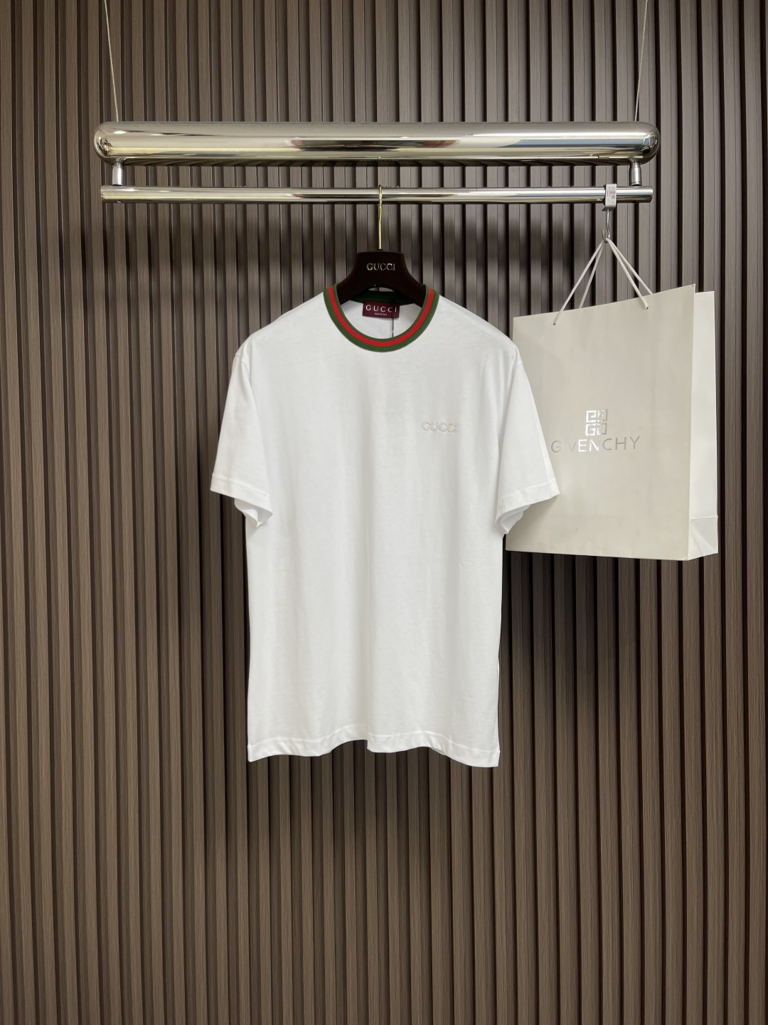 NO:134325,GUCCI 2025ss new neckline with webbing short-sleeved T-shirt, brand elements continue to be renewed, interpreting casual style T-shirts and knitted clothing. This short-sleeved T-shirt is made of lightweight knitted cotton, embellishing gucci logo patches and red and green webbing piping. Pure cotton knitted plain fabric, using 15s fine cotton plain fabric, 230g. Plain wrinkle fabric made of cotton fiber treated with combed process, compared with ordinary cotton fabrics, its fiber arrangement is more neat and dense, so it has better texture and luster. Red and green webbing piping, gucci  Logo embroidery patch, rice-grain needle patch embroidery technology is a traditional hand-made embroidery technique that combines three-dimensional needlework and patch inlay, giving the single product a unique texture and artistic sense. The cuffs and bottom edges are used to fix the edges of the special machine. Size XS-L, gucci, T-shirt, tees, t-shirt, alexander wang19860909GUCCI 2025ss新款 领口饰织带短袖t恤,品牌元素持续焕新,演绎休闲风t恤和针织服饰.这款短袖t恤以轻质针织棉打造,缀饰gucci标识贴饰和红绿织带滚边.纯棉质针织平纹面料,采用15s精棉平纹面料,230g.采用精梳工艺处理的棉纤维制成的平纹织物,相对于普通棉布而言,它的纤维排列更加整齐、密度更高,因此具有更好的质地和光泽.红绿织带滚边,gucci 标识刺绣贴饰,米粒针贴布刺绣工艺是一种结合立体针法与贴布镶嵌的传统手工刺绣技艺,赋予单品独特的肌理感和艺术性.袖口、下摆底边采用的分别专机辑双明线收边固定.尺码XS-L,,gucci,T-shirt,tees，t-shirt,alexander wang,Men's clothing