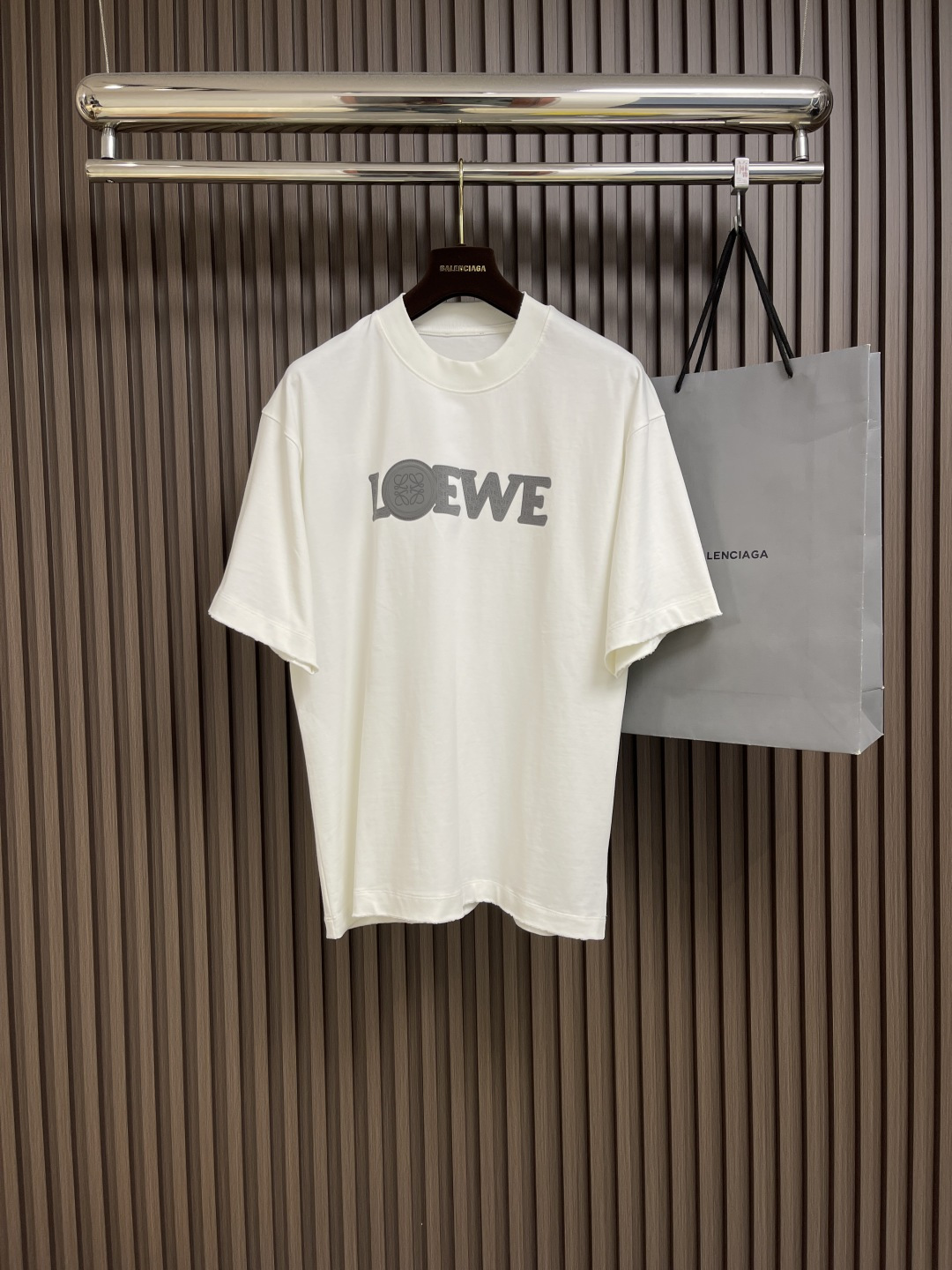 NO:144709,loewe  Luo Yiwei patch embroidery short-sleeved T-shirt, lightweight pure cotton fabric, using 15s fine cotton plain pattern, 230g. Fine cotton fabric usually has good moisture absorption, breathability, warmth and wear resistance, and is also soft and smooth. Retro fine cotton fabric is thicker with retro style tones, and has fine processing and processing, with excellent texture and performance. Due to the fine processing, the fine cotton fabric is lighter and thin, soft and comfortable to touch, and it is very suitable for the skin when worn. The sleeves are decorated with anagram hollow design, and the patch embroidery is a kind of cutting  The process of sewing good fabrics on the fabric to form three-dimensional decorative patterns is both practical and artistic, and using the superposition of different fabrics to create a sense of layering. The laser cutting technology uses a high-power density laser beam to irradiate on the surface of the material to be cut to realize the cutting and processing technology. The process of stir-frying sand and making old after garment is made by stir-frying the color process, and the new environmentally friendly process of garment is transfected and dyed, washing water and making old. The fabric is dyed and processed through the stone milling method, and the garment is constantly immersed in the dye and rolled. The fabric faded slightly after garment is frying, and the color of the original fabric is changed to show nostalgic colors of different shades and light and dark.  Simple vertical round neck short-sleeved style, the paper pattern is developed to develop extremely simple body cutting, knitted material has certain extension performance, and the upper body will not be tightly tied. The round neck is the same color ribbed splicing collar, and the inner patching process of the back neck effectively prevents the neckline deformation after multiple washes, fit shoulder line, bottom swing and cuff special machine knight and car open line edge. Size M-XXL M size shoulder width 52cm bust 117cm long 72cm L size shoulder width 53.5cm bust 121cm long 74.5cm xL size shoulder width 55cm bust 125cm long 76.5cm xXL size shoulder width 56.5cm bust 129cm long 78.5cm, loewe,loewe,T-shirt,tees,t-shirt,alexander wang19860909loewe 罗意威贴布绣刺绣短袖T恤,轻盈质地纯棉质面料,采用15s精棉平纹,230g.精棉面料通常具有较好的吸湿性、透气性、保暖性和耐磨性,同时也比较柔软和光滑.复古精棉面料比较厚实的棉质面料,具有复古风格的色调,同时经过精细加工和处理,具有优良的质地和性能.由于经过了精细加工,精棉面料的质地比较轻薄,手感柔软舒适,穿着起来非常贴合皮肤.衣袖饰有anagram镂空设计,贴布绣是一种通过将裁剪好的布料缝制在织物上,形成立体装饰图案的工艺,兼具实用性与艺术性,利用不同面料的叠加创造层次感.激光切割技术是利用高功率密度的激光束,照射在待切割材料表面,实现切割加工技术.成衣后炒砂做旧工艺,成衣后进行炒色工艺制作而成,成衣环保新工艺转染染色、洗水做旧.通过石磨的方式对面料进行染色加工,成衣不断地浸入染料中翻滚.炒砂后面料轻微掉色效果,改变原面料颜色呈现出深浅一明暗不同的怀旧色彩. 简约垂直圆领短袖版型,对版纸样开发极简直身剪裁,针织材质具有一定延展性能,上身不会紧紧束身.圆领同色罗纹拼接领口,后领口内贴条工艺,有效防止多次穿洗后领口变形,合身肩线,底摆与袖口专机坎车明线收边.尺码M-XXL M码肩宽52cm 胸围117cm 衣长72cm L码肩宽53.5cm 胸围121cm 衣长74.5cm XL码肩宽55cm 胸围125cm 衣长76.5cm XXL码肩宽56.5cm 胸围129cm 衣长78.5cm,,loewe,loewe,T-shirt,tees，t-shirt,alexander wang,Men's clothing