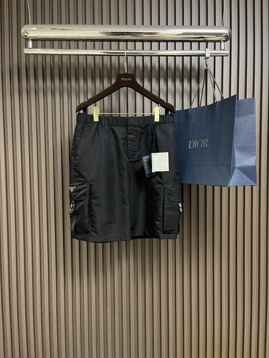 NO:152620,Prada 2025SS new Bermuda shorts, these Bermuda shorts are equipped with large side pockets, nylon straps and side buckles, giving a simple and practical functional design. The trousers are made of Re-Nylon recycled nylon, and the side pockets are decorated with the iconic enamel metal triangular TM heart mark, zippered placket, and hidden hook buckles.  Front angled open bag, back zippered wire inlay bag, details show the brand style, size 46-52 S-XL, prada, shorts, alexander wang19860909Prada 2025SS新款百慕大短裤,这款百慕大短裤配有大号侧面口袋、尼龙饰带和旁开扣,呈现简约、实用的功能性设计.裤身采用Re-Nylon再生尼龙打造,侧面口袋饰以标志性的涂珐琅金属三角TM心标,拉链门襟,配隐藏式钩扣．正面斜角开袋,背面拉链式嵌线袋,细节之处彰显品牌格调,尺码46-52 S-XL,,prada,shorts,alexander wang,Men's clothing