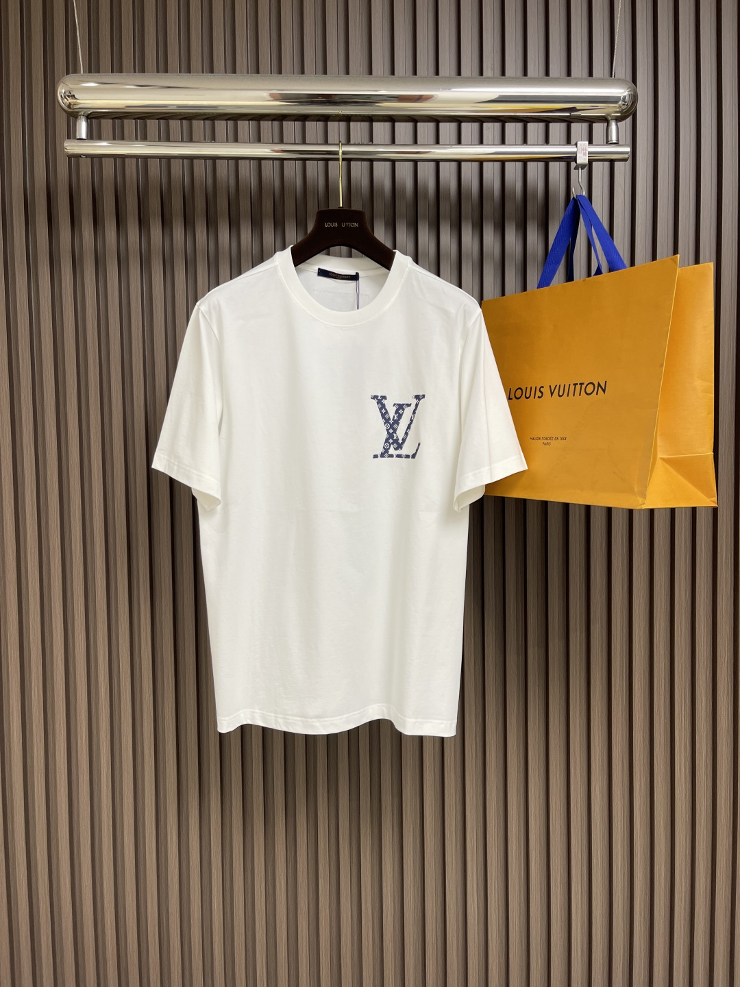 NO:422069,LV denim old-fashioned logo white short-sleeved T-shirt, classic and fashion collision, this white short-sleeved look came out. The iconic denim old-fashioned 'V' logo is cleverly embellished on the chest, and the retro charm and trendy style blend, instantly becoming the visual focus. The unique fabric design on the back shows the brand's heritage. The selection of 99% cotton and 1% polyester fabric is skin-friendly and breathable, and the comfort is full. The loose style is suitable for diverse outfit scenes. Whether you are walking on the street or attending casual parties, you can easily control it, helping you to calmly interpret French luxury style. Size XS-L,,louis vuitton, T-shirt,tees, t-shirt,alexander wang19860909LV 牛仔老花标识白色短袖T恤,经典与时尚碰撞,这款白色短袖瞩目登场.标志性牛仔老花'V'标识,巧妙缀于胸前,复古韵味与潮流格调交融,瞬间成为视觉焦点.后背独特布标设计,低调彰显品牌底蕴.甄选99％棉与1％聚酯纤维面料,亲肤透气,舒适感拉满.宽松版型,适配多元穿搭场景,无论是漫步街头,还是出席休闲聚会,皆能轻松驾驭,助你从容诠释法式奢华风尚.尺码XS-L,,louis vuitton,T-shirt,tees，t-shirt,alexander wang,Men's clothing