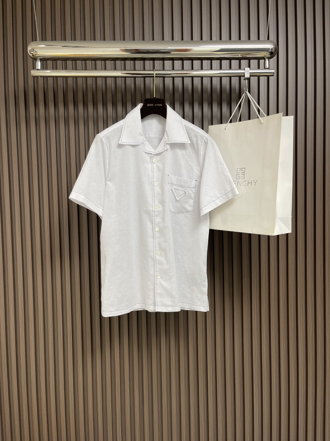 NO:418657,Prada bright linen short-sleeved shirt, this linen shirt uses bowling lapels, which are clearly outlined with contrasting stitching, embellishing the classic triangle logo in the same color. Oversize shape, bowling lapels, classic chest pockets, straight bottom edge, mother-of-pearl button closure, front fabric triangle logo. Size S-XXL S shoulder width 45cm bust 110 Long 75 Sleeve length 23 M shoulder width 46cm bust 114 Long 76 Sleeve length 24 L shoulder width 47cm bust 118 Long 77 Sleeve length 25 XL shoulder width 48cm bust 122 Long 78 Sleeve length 26 XXL shoulder width 49cm bust 126 Long 79  Sleeve length 27, prada, versace,shirts,T-shirt,alexander wang19860909Prada 明线亚麻短袖衬衫,这款亚麻衬衫采用保龄球翻领,以反差缝线鲜明勾勒廓形,点缀经典同色系三角形徽标.Oversize造型,保龄球翻领,经典胸袋,平直底边,珍珠母纽扣开合,正面织物三角形徽标.尺码S-XXL S肩宽45cm 胸围110 衣长75 袖长23 M肩宽46cm 胸围114 衣长76 袖长24 L肩宽47cm 胸围118 衣长77 袖长25 XL肩宽48cm 胸围122 衣长78 袖长26 XXL肩宽49cm 胸围126 衣长79 袖长27,,prada,versace,shirts,T-shirt,alexander wang,Men's clothing