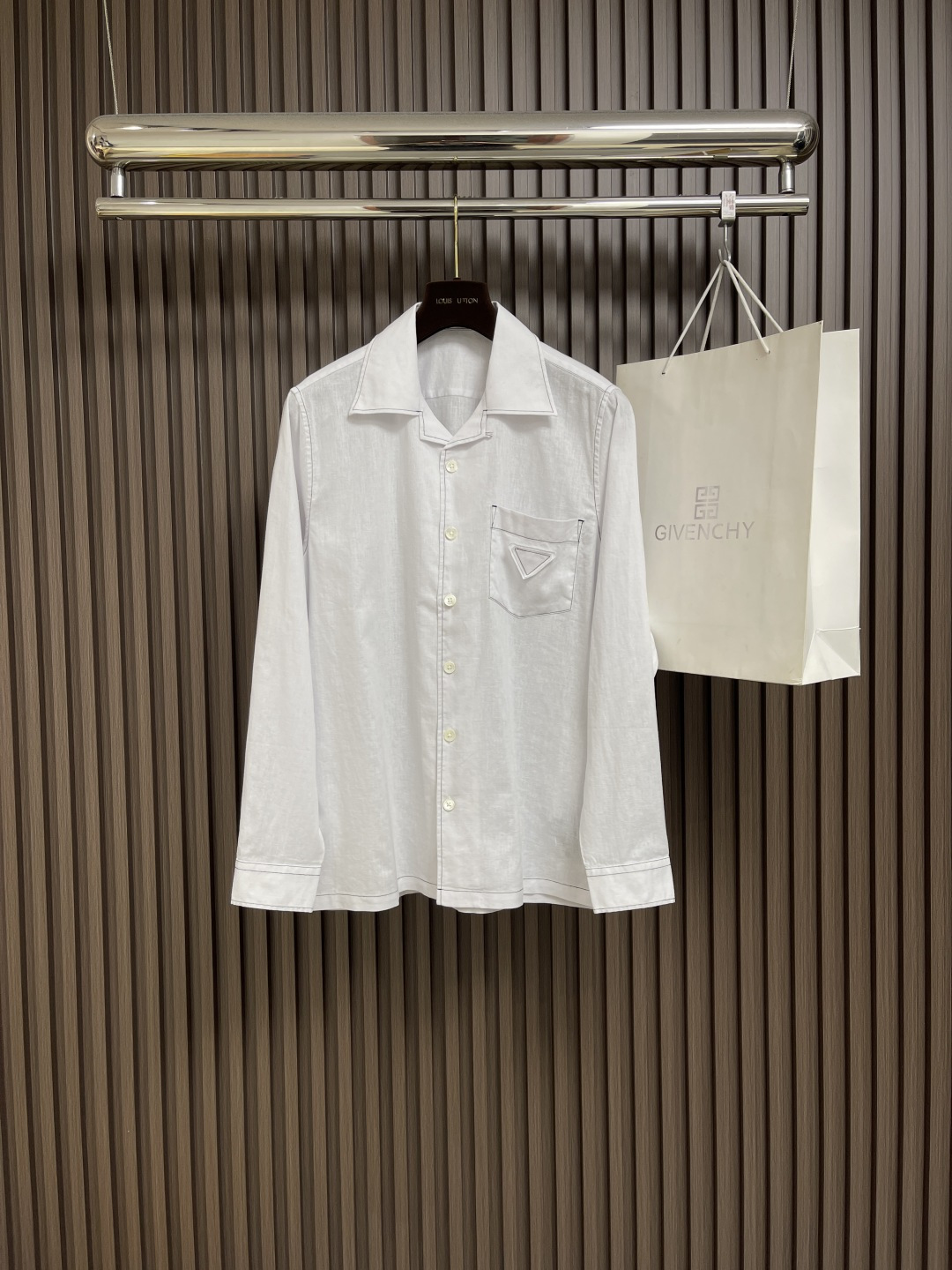 NO:418682,Prada bright linen long-sleeved shirt, this linen shirt uses bowling lapels, which are clearly outlined with contrasting stitching, embellishing the classic triangle logo in the same color. Oversize shape, bowling lapels, classic chest pockets, straight bottom edge, mother-of-pearl button closure, front fabric triangle logo. Size S-XXL S shoulder width 45cm bust 110 Length 75 sleeve length 64 M shoulder width 46cm bust 114 Length 76 sleeve length 65 L shoulder width 47cm bust 118 Length 77 sleeve length 66 XL shoulder width 48cm bust 122 Length 78 sleeve length 67 XXL shoulder width 49cm bust 126 Length 79 sleeve length 68,,prada,versace,shirts,alexander  wang19860909Prada 明线亚麻长袖衬衫,这款亚麻衬衫采用保龄球翻领,以反差缝线鲜明勾勒廓形,点缀经典同色系三角形徽标.Oversize造型,保龄球翻领,经典胸袋,平直底边,珍珠母纽扣开合,正面织物三角形徽标. 尺码S-XXL S肩宽45cm 胸围110 衣长75 袖长64 M肩宽46cm 胸围114 衣长76 袖长65 L肩宽47cm 胸围118 衣长77 袖长66 XL肩宽48cm 胸围122 衣长78 袖长67 XXL肩宽49cm 胸围126 衣长79 袖长68,,prada,versace,shirts,alexander wang,Men's clothing