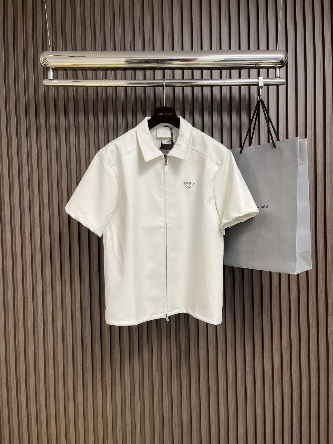 NO:451406,PRADA double-sided lambskin zipper shirt, 0.5*2 composite double-sided lambskin, original fabric is fixed in apricot grey, and custom cross-embossed fabric. The style is customized from 1000 meters, and the ready-to-wear effect is high-end. The neckline leather trademark is processed in the same color and material, and the imprinting process is made with the brand's iconic LOGO. The zipper is electroplating for gun black, and the chest leather label is enamel plating. This short-sleeved shirt is designed with sporty style, showing exquisite design and simple style with Nappa leather, reinterpreting the classic style. Size S-XL, prada,shirts, T-shirt, sheepskin, alexander wang19860909PRADA 双面小羊皮拉链衬衫,采用0.5*2复合双面小羊皮,面料原版定染杏灰色,面料定制交叉压纹.1000米起定款式,成衣效果呈现出高级风.领口皮商标采用同色同料加工,做了压印工艺带有品牌标志性LOGO.拉链采用电镀做枪黑色,胸口皮标珐琅电镀.这款短袖衬衫采用运动风设计,以Nappa皮革呈现精致设计和简约风尚,重新诠释经典格调.尺码S-XL,,prada,shirts,T-shirt,sheepskin,alexander wang,Men's clothing