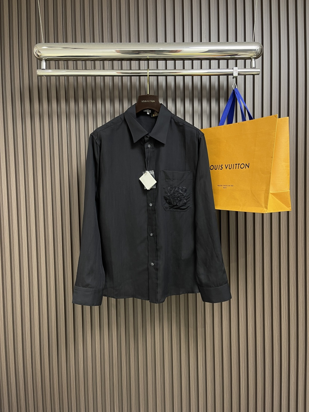 NO:428060,Loewe 2025SS summer new embroidered linen long-sleeved shirts are fused with viscose fiber and linen, and fiber interlocking is achieved through air-flow spinning technology. The smooth drape of viscose fiber neutralizes the rough texture of flax. The skinny support of flax makes up for the deformable shortcoming of viscose fiber. The high moisture absorption rate of viscose fiber is linked to the porous fiber structure of flax to form a dual-channel sweating system. The wrinkle resistance and drape feel are combined, reflecting the characteristics given by the fusion of the two fibers. The Anagram totem of the breast patch pocket adopts an implicit hook-and-needle embroidery process, and the 320-needle CM2 precision matrix is ​​evolved on the linen substrate with extremely thin filament thread, which resonates with the natural texture of the fabric. The inner lining is implanted with a tensile mesh substrate to ensure that the embroidery remains flat as before after frequent use. Size 46-52,,loewe,shirts,alexander wang19860909Loewe 2025SS夏季新款绣花亚麻长袖衬衫,以粘胶纤维与亚麻融合,通过气流纺纱技术实现纤维互锁,粘纤的柔滑垂坠感中和亚麻的粗粝肌理,亚麻的骨感支撑力弥补粘纤易变形的短板.粘纤较高的吸湿率与亚麻的多孔纤维结构联动,形成双通道排汗系统.抗皱性与垂坠感兼得,体现两种纤维融合赋予的特性.胸前贴袋的Anagram图腾,采用隐式勾针刺绣工艺,以极细丝线在亚麻基底上演化出320针CM2的精密矩阵,与布料天然纹理同频共振.内衬植入抗拉伸网纱衬底,确保频繁使用后刺绣依然平整如初.尺码46-52,,loewe,shirts,alexander wang,Men's clothing