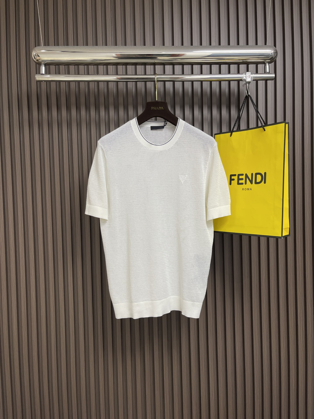 NO:437449,Prada 2025ss new triangular logo hollow mesh knitted T-shirt continues its ultimate pursuit of material and structure. This knitted short sleeve adopts breathable mesh design to create a light and cool dressing experience. The whole piece adopts high-density knitting techniques, which not only ensures the three-dimensional style but also enhances the overall texture. The same-color triangle logo embroidery vaguely visible on the chest presents the brand's consistent restraint and exquisiteness. Sizes S-XXL, prada, T-shirt, tees, t-shirt, alexander wang19860909Prada 2025ss新款三角标镂空网眼针织T恤,延续对材质与结构的极致追求,这款针织短袖采用透气网眼设计,营造轻盈凉感的穿着体验.整件采用高密针织技法,既保证了立体版型,又提升了整体质感.胸前隐约可见的同色三角Logo刺绣,呈现品牌一贯的克制与精致.尺码S-XXL,,prada,T-shirt,tees，t-shirt,alexander wang,Men's clothing