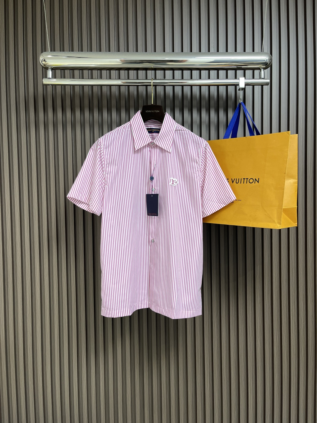 NO:461400,LV striped contrasting color short-sleeved shirt is made of high-quality cotton, with soft and comfortable texture. The fabric is made of classic Monogram jacquard and bright striped prints on the surface to form a unique visual sense of layering. The standard design is designed with exquisite pointed collar shapes, and pearlescent buttons are selected at the details and metal bases to highlight the exquisite craftsmanship of the brand. The Flower rubber patch specially designed on the chest becomes the finishing touch, highlighting the brand's logo and adding a three-dimensional texture to the whole. It can be perfectly matched with the same series of striped items to create a layered layered layered shape. The fabric has been specially treated to ensure that it is clean and stylish while maintaining the natural breathability of cotton. Every detail has been carefully considered, from jacquard weaving to printing technology to embellishment, all reflect the ultimate pursuit of quality. Size S-XL,,louis  vuitton,shirts,T-shirt,alexander wang19860909LV 条纹撞色短袖衬衫,采用优质棉料制成,质地柔软舒适.面料以经典Monogram提花为底纹,表面叠加鲜明条纹印花,形成独特的视觉层次感.采用标准版型设计,搭配精致的尖领造型,细节处选用珠光纽扣并配以金属底座,彰显品牌精湛工艺.胸前特别设计的 Flower橡胶贴饰成为点睛之笔,既突出了品牌标识,又为整体增添立体质感.该可与同系列条纹单品完美搭配,打造富有层次感的叠穿造型.面料经过特殊处理,确保穿着挺括有型,同时保持棉质的天然透气性.每一处细节都经过精心考量,从提花织造到印花工艺,再到点缀,无不体现对品质的极致追求.尺码S-XL,,louis vuitton,shirts,T-shirt,alexander wang,Men's clothing