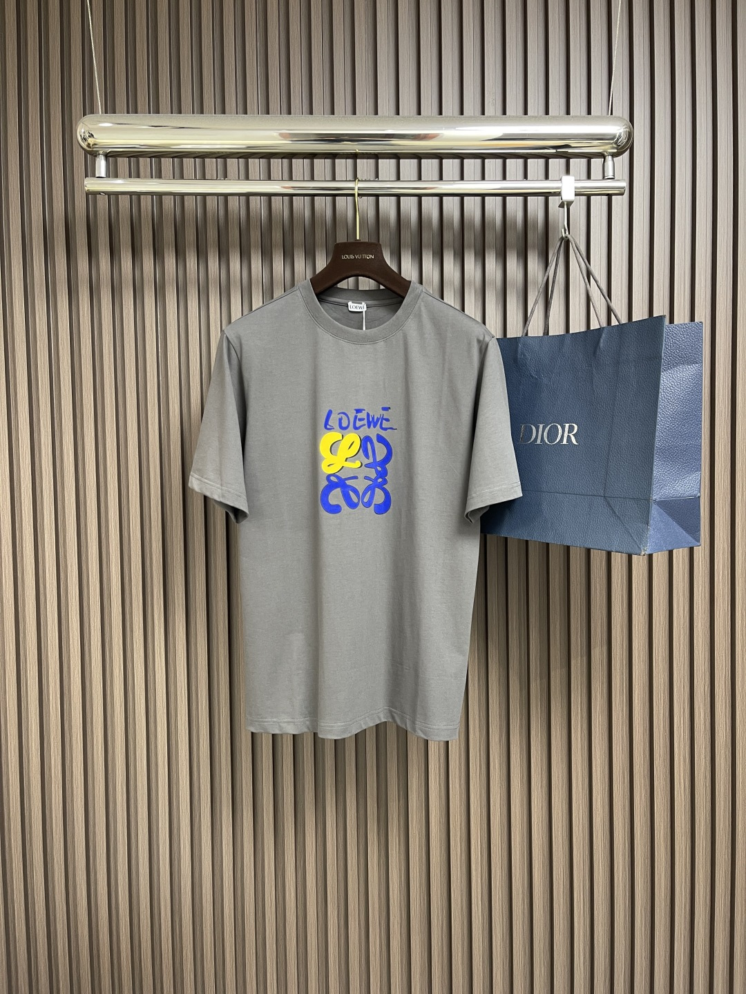 NO:455449,loewe colorful graffiti printed short-sleeved T-shirt, a collision of street art and comfort, this short-sleeved piece brings street graffiti art into daily outfits!  Tightly knitted cotton fabric, skin-friendly and textured, comfortable to wear close to the body, as if wrapped in clouds. The gray background is simple and high-end, the LOEWE colorful graffiti print on the chest is super eye-catching, the yellow and blue color combination is lively and eye-catching, breaking the monotony, and the street trend is full. Whether it is a boy who is cool and handsome on the street or a girl who plays with her underwear missing, she can easily grasp the fashionable style. Size XS-L,,loewe,T-shirt,tees,t-shirt,alexander wang19860909loewe 炫彩涂鸦印花短袖T恤,街头艺术与舒适的碰撞,这件短袖,把街头涂鸦艺术搬进日常穿搭！紧密针织棉面料,亲肤又有质感,贴身穿舒适到像被云朵裹住.灰色底色简约又高级,胸前LOEWE炫彩涂鸦印花超吸睛,黄蓝配色活泼亮眼,打破单调,街头潮流感拉满,不管是男生酷帅出街,还是女生玩下衣失踪、都能轻松拿捏时髦范儿.尺码XS-L,,loewe,T-shirt,tees，t-shirt,alexander wang,Men's clothing