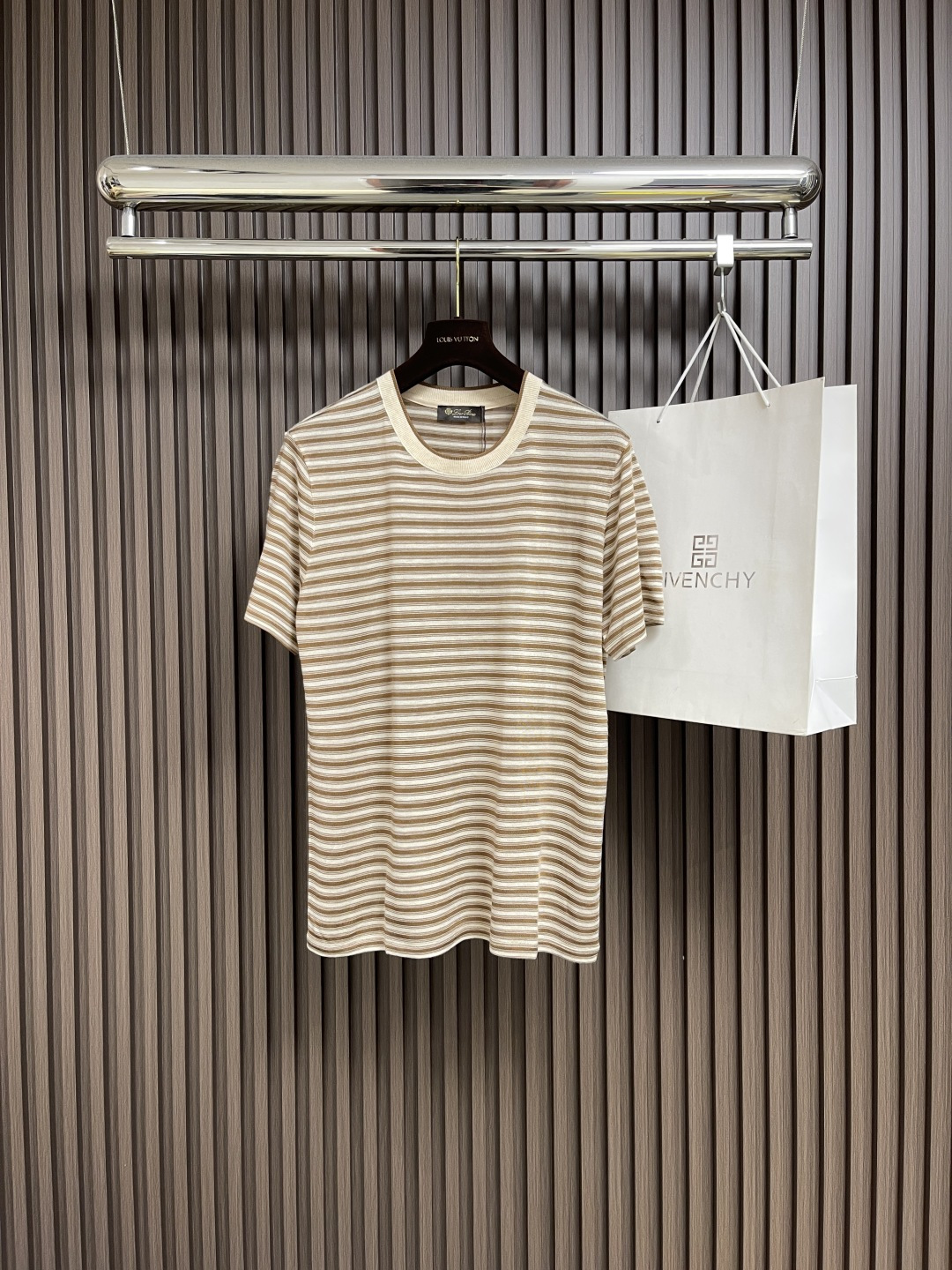 NO:495648,LP Loro Piana  SS brown striped round neck short-sleeved T-shirt, linen and recycled fiber blended striped round neck short-sleeved, based on the natural relaxation of linen, blending the environmentally friendly toughness of recycled fibers, woven the breathing feeling of 16-needle small round knitted fabric. 4 French Normandy linen and recycled cellulose fiber interwoven, retaining the breathability and antibacterial characteristics of linen, and giving the fabric a drooping bones. After washing and pre-shrinking, the touch feels as smooth as clouds and stable as sculptures. Remove the wrinkle easily, and retain the calmness of time taming. Inspired by the tidal rhythm along the Mediterranean coast. Each pattern is soaked by plant dyes and colored after 30 days  Art, color fastness is above level 5, and it becomes more warm and old after washing, as if it has left marks after being kissed by the sea breeze. The neckline horizontal machine knitted rib collar is accurately sealed with a 0.3mm mouthpiece machine, fitting the neck curve without marks, embedded invisible support yarn, and not deforming after long-term wear; the flat car seam process, the seam density reaches 16 stitch centimeters, and the boneless seam is as light as the second layer of skin. The cut H-shaped contour is fixed by high-temperature ironing, the shoulder thread is slightly lowered, and the cuffs are folded and double needles are tightly copied, and the precise proportion is hidden in laziness. The pre-shrinkage process adopts low-temperature steam shaping technology to avoid chemical softener residue. Size S-M-L, loro  piana,loro piana,T-shirt,tees,t-shirt,alexander wang19860909LP Loro Piana SS咖色条纹圆领短袖T恤,亚麻与再生纤维混纺条纹圆领短袖,以亚麻的天然松弛为基底,糅合再生纤维的环保韧性,织造出16针小圆机针织面料的呼吸感.4法国诺曼底亚麻与再生纤维素纤维交织,既保留亚麻的透气性与抗菌特质,又赋予面料垂坠筋骨,经洗水预缩定型后,触感如云絮般柔滑,形态稳定如雕塑﹣﹣褪去易皱的桎梏,留存时光驯服的从容.灵感源自地中海沿岸的潮汐律动.每一道纹路由植物染料浸染,经30天定色工艺,色牢度达5级以上,水洗后愈显温润做旧质感,仿若被海风亲吻过的岁月留痕.领口横机针织罗纹领,以0.3mm套口机精准封盘,贴合颈部曲线而不勒痕,内嵌隐形支撑纱线,久穿不变形；平车拼缝工艺,缝线密度达16针厘米,无骨接缝如第二层肌肤般轻盈.剪裁H型廓形经高温整烫定型,肩线微落,袖口内折双针密拷,慵懒中暗藏精准比例.预缩工序采用低温蒸汽定型技术,避免化学柔顺剂残留.尺码S-M-L,,loro piana,loro piana,T-shirt,tees，t-shirt,alexander wang,Men's clothing