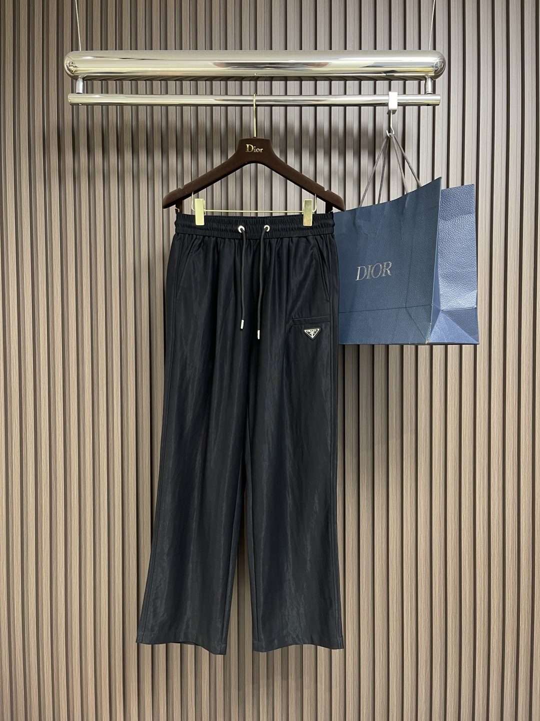 NO:475891,Prada Tencel Linen Elastic Waist Drawstring  Casual pants, on the fashionable and comfortable track, this Tiansi elephant waist drawstring casual pants are undoubtedly the well-deserved leader. It redefines the standards of high-end casual pants with exquisite craftsmanship and unique design. Selects Tiansi and linen blend fabrics to perfectly combine the smoothness of Tiansi and the texture of the sesame seeds. Tiansi fiber brings a silk-like delicate touch, gently sticking to the skin, as comfortable as the second layer of skin; the sesame seeds give the fabric natural texture and breathability, and can quickly expel moisture and keep the legs dry even in the stuffy season. This fabric combination is not only comfortable, but also has an excellent drape, making the pants naturally and smooth.  The waist is elegant. The design of elastic straps and drawstrings is a model of comfort and practicality. The high elastic elastic waist can perfectly fit all waistlines without being tight and easy to wear. The metal decorative head at the end of the drawstring is carefully polished and has a high gloss, which not only adds the exquisiteness of details, but also demonstrates the brand's ultimate pursuit of quality. The metal triangle logo on the front and rear pockets is a symbol of PR** identity. The logo is made of high-quality metal material and is finely polished to present a low-key and luxurious luster. Size XS-L, prada, alexander  wang19860909Prada 天丝亚麻松紧腰抽绳 休闲裤,在时尚与舒适的赛道上,这款天丝麻松紧腰抽绳休闲裤无疑是当之无愧的领跑者,它以精湛工艺与独特设计,重新定义高端休闲裤的标准.甄选天丝与麻混纺面料,将天丝的柔滑与麻料的质感完美融合.天丝纤维带来丝绸般的细腻触感,轻柔贴肤,如第二层肌肤般舒适；麻料则赋予面料天然的纹理与透气性,即使在闷热的季节,也能快速排出湿气,保持腿部干爽.这种面料组合不仅舒适,还具有出色的垂坠感,让裤型自然流畅,行走间尽显优雅.腰部采用松紧带与抽绳双结合的设计,堪称舒适与实用的典范.高弹性的松紧腰头能完美贴合各种腰围,不紧不勒,穿着自在.抽绳末端的金属饰头,经过精心打磨,光泽度高,不仅增加了细节的精致感,更彰显品牌对品质的极致追求.前侧口袋和后侧口袋上的金属三角徽标,是PR*＊身份的象征.徽标采用高品质金属材质,经过精细抛光处理,呈现出低调而奢华的光泽.尺码XS-L,,prada,alexander wang,Men's clothing