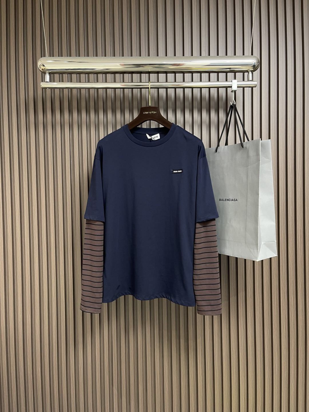 NO:499904,MIU MIU Brown Stripe Fake Two-piece Long Sleeve T-shirt, using 24S Jacquard Stripe crafts special textile tight cotton, 200g; matched with the complex weaving technology of jacquard technology, the striped pattern is formed through the interlacing of warp and weft yarns, giving the fabric three-dimensional and layered sense, visually more advanced. The stripes are presented through jacquard technology, which lasts longer than ordinary printing or dyed stripes, and are not easy to fade. The texture is clear and the boundaries are clear. The style of classic retro and modern modern is fashionable, and can be matched with matching tool jeans to create an overall look!  The same style for men and women!  Size XS-L, miumiu, jeans, tees, t-shirt, alexander wang19860909MIU MIU 棕条纹假两件长袖T恤,采用24S提花条纹工艺特种纺织紧密棉, 200g；搭配提花工艺复杂织造技术,通过经纬纱线的交错形成条纹图案,赋予面料立体感和层次感,视觉上更显高级.条纹通过提花工艺呈现,比普通印花或染色条纹更持久不易褪色,且纹理清晰、边界分明,经典复古与现代摩登结合的风格,设计时尚,可与配套的工装牛仔裤搭配,打造整体造型！男女同款！尺码XS-L,,miumiu,jeans,tees，t-shirt,alexander wang,Men's clothing