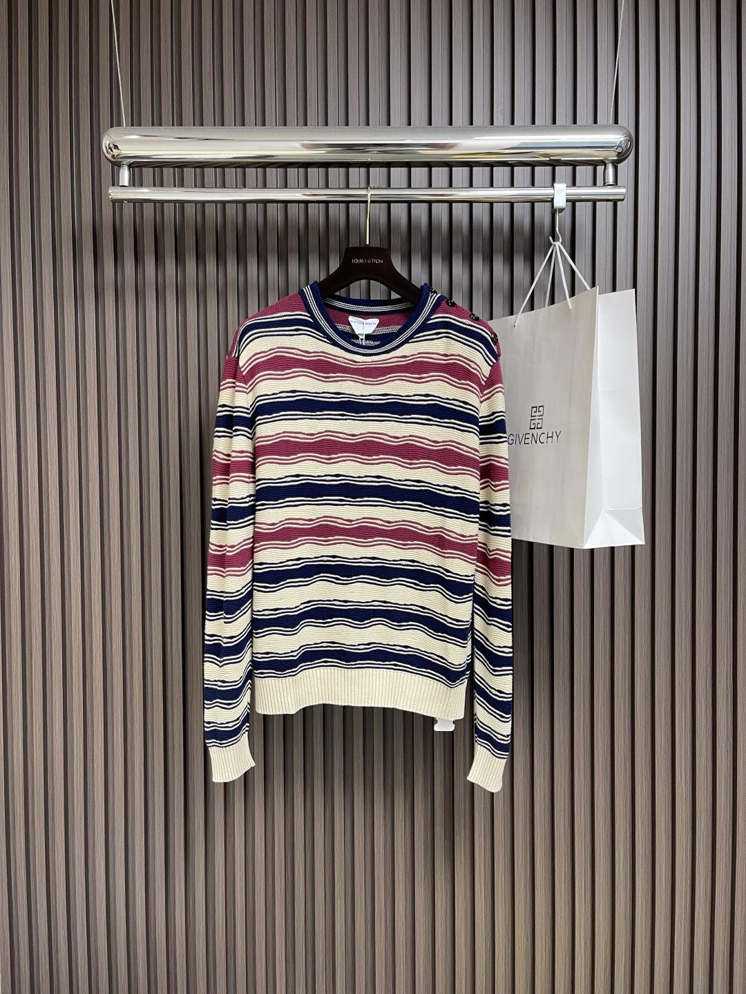 NO:490147,BV Bottega Veneta linen three-color striped knitted sweater is carefully woven with high-quality linen and cotton blended yarn. The three colors are exclusively branded with a fixed-dyeing process to ensure that the color is exactly the same as the original. The fabric is made of natural linen, which has the characteristics of lightness and breathability, and is comfortable and not stuffy. The brand's ingenious craftsmanship can be seen in the details, and the lacquered three-eye real horn buttons are specially customized. Each one is hand-sewn by a craftsman. The clever embellishment of Merlot red adds a high-end texture to the overall design and complements the striped elements. The whole sweater is exquisitely crafted, and from the yarn selection to the dyeing process is strictly controlled to ensure that the Bottega is presented.  Veneta's signature exquisite aesthetics. The striped patterns are arranged neatly and evenly, and the knitting density is just right, which not only ensures the crispness of the style, but also retains the unique natural drooping of the linen fabric. Size S-M-L, bottega veneta, bottega veneta, sweaters, alexander wang19860909BV Bottega Veneta亚麻三色条纹针织毛衣,采用优质亚麻棉混纺纱线精心织就,三种色调均为品牌专属定织定染工艺,确保色彩与原版完全一致.面料选用天然亚麻材质,具有轻薄透气的特性,穿着舒适不闷热.细节处可见品牌匠心工艺,特别定制漆面三眼真牛角纽扣,每一颗都由工匠手工缝制完成.梅洛红的巧妙点缀为整体设计增添高级质感,与条纹元素相得益彰.整件毛衣做工考究,从纱线选择到染色工艺都严格把控,确保呈现Bottega Veneta标志性的精致美学.条纹图案排列整齐均匀,针织密度恰到好处,既保证了版型的挺括感,又保留了亚麻面料特有的自然垂坠感.尺码S-M-L,,bottega veneta,bottega veneta,sweaters,alexander wang,Men's clothing