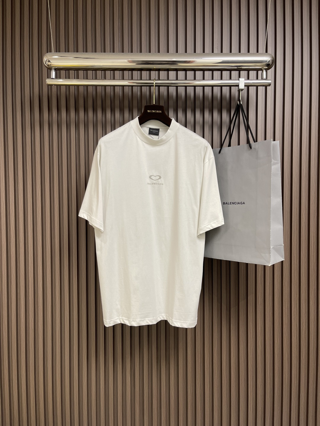 NO:499954,Balenciaga Chinese Valentine's Heart-To-Drawing Round Neck Short-Sleeved T-Shirt, Jersey, Neutral Style, Round Neck Short-Sleeved, Front Decorated with Chinese Valentine's  25 art works embroidery, the back is decorated with the same print, and a full set of auxiliary materials. Retro jersey fabric is made of 24S double yarn retro jersey fabric, 185g; matched with 32S double yarn 1*1 thread, 270g.24S fabric is a medium thick yarn, suitable for creating thick and crisp fabrics, with a slightly rough texture, which conforms to the 'natural and original' effect pursued by retro style. The texture is soft, breathable and elastic, suitable for close-fitting wear, can  Create a simple and smooth outline. Through old texture and fading, combined with classic tailoring, the retro feel is reflected in the details of the loose contour design. The main body adopts precision needle embroidery process; the embroidery is very fine and dense, with clear patterns and strong three-dimensional sense. The linen embroidery thread is combined with encryption, and the embroidery body has a subtle matte visual texture; the embroidery effect is three-dimensional and full. The flat embroidery thread is uniquely designed, and the embroidery is very fine and dense; the overall stitching is fine and fine.  The consistent feeling adds a sense of layering to the simple design. The printing on the back uses a reducing agent to destroy the molecular structure of the fabric dye, accurately removes local colors instead of simply covering. The pattern after the printing is integrated with the fabric, making the touch more natural, without any glue or heavy feeling. The 'bottom color peeling' is achieved through chemical reactions to form a light-colored pattern with strong contrast; high-precision laser positioning and deprinting technology is used to ensure the edge clarity of complex patterns. The high-collar oversize loose version  Stylish, oversize loose silhouette design, basic round neck neckline with shoulder line, vertical pit bar code from top to bottom, neckline, cuffs and hem all have zippers, and the sleeves are longer and protruding to the details. The thickness of the ready-to-wear is consistent with the original version, and it is shaped separately, and the upper body is wide and not easily deformed. Size XS-L,,balenciaga, versace,T-shirt,tees,t-shirt,alexander  wang19860909Balenciaga 七夕心意图案圆领短袖T恤,平纹针织面料、中性款型、圆领短袖、正面饰以七夕 25艺术作品刺绣、背面饰以同款印花、全套辅料配备,复古平纹针织面料,采用24S双纱复古平纹针织面料,185g；搭配32S双纱1*1螺纹,270g.24S面料属于中等偏粗的纱线,适合打造厚实、挺括的面料,质感略带粗糙感,符合复古风格追求的'自然原始'效果.质地柔软、透气且有一定弹性,适合贴身穿着,能塑造简约流畅的轮廓.通过做旧纹理、褪色处理,结合经典剪裁体现复古感宽松廓形设计细节.主体采用精密挨针绣工艺；刺绣非常精细针法绵密,图案清晰且线条感和立体感强.亚麻材质绣线结合加密处理,绣体具有微妙的哑光视觉质感；刺绣效果立体饱满.平绣的挨针走线独特设计,刺绣非常精细针法绵密；整体针脚细密,精细度质感一致,为简约设计增添了层次感.背面拔印印花使用还原剂破坏面料染料分子结构,精准去除局部颜色,而非简单覆盖.拔印后的图案与面料融为一体,触感更自然,无胶感或厚重感.通过化学反应实现'底色剥离',形成反差强烈的浅色图案；采用高精度激光定位拔印技术,确保复杂图案的边缘清晰度.高领oversize宽松版型,oversize宽松廓形设计,基础款圆领领口落肩线,自上而下采用纵向坑条织码,领口、袖口、下摆均有罗口收口,袖长更偏长突出细节感.成衣厚度与原版一致,另做定型处理,上身挺阔不易变形.尺码XS-L,,balenciaga,versace,T-shirt,tees，t-shirt,alexander wang,Men's clothing