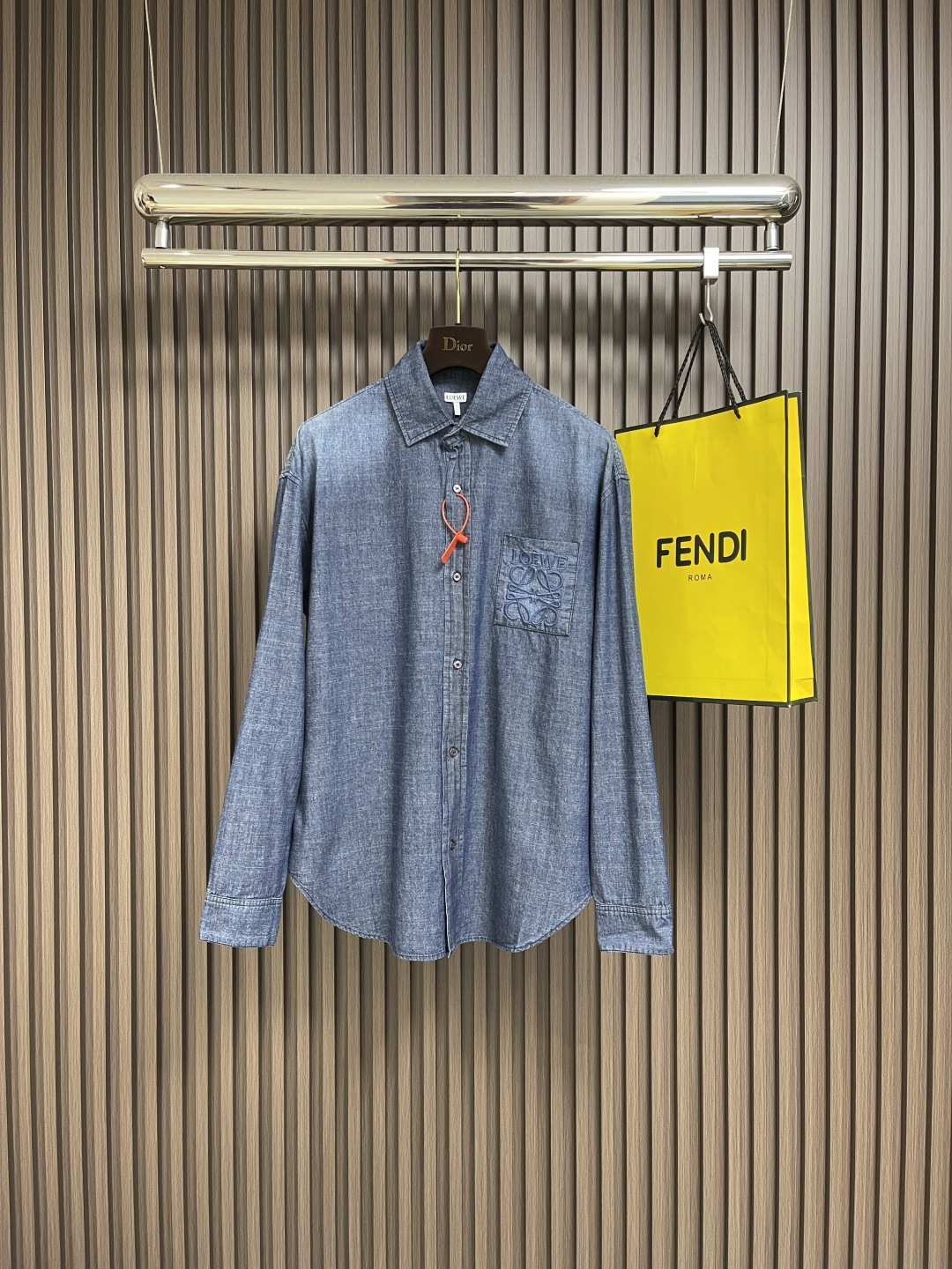 NO:521418,Loewe Anagram Gradient embroidered pocket shirt, customized high-quality cotton youth cloth expensive fabric, with a unique washing gradient blue as the main tone, from deep to shallow, from thick to light, with Loewe on the chest patch pocket decorated with Loewe  Anagram embroidery is the soul, engraved with LOEWE casual and elegant, natural and smooth lines, which show their casualness and freedom. The imported machine embroidery is used, and the advanced computer control system and precise mechanical components are used to realize Loewe embroidery operation. Gradient dynamic spray dyeing technology uses special spray dye to accurately spray the dye onto the surface of the fabric in a mist form (by precisely controlling the spray dyeing equipment's spraying speed and direction in combination with the movement speed and direction during the dyeing process) to present a smooth and natural transition effect of the color. Butterfly clamping pleats are used to inspire the beautiful form of butterflies, and through the precise clamping technique, agile folding effect is created on the clothing, making the clothing more fitting to the body. Size 44-46-48-50 S-XL,,loewe,shirts,alexander wang19860909Loewe Anagram 渐变刺绣口袋衬衫,定制优棉青年布贵织面料,以独特的水洗渐变蓝为主基调,从深至浅 由浓转淡,胸前贴袋饰以Loewe Anagram刺绣为灵魂所在,镌刻LOEWE式随性优雅,自然流畅的线条尽显随性洒脱.采用进口机绣花,使用先进的计算机控制系统和精密的机械部件,实现Loewe绣花作业.渐变动态喷染工艺,利用专门的喷染设备,将染料以雾状的形式精准地喷射到布料表面（通过精确控制喷染设备的喷射不同维度,结合染过程中的移动速度和方向）呈现颜色的平滑自然过渡效果,蝶韵捏褶合体省道技术,以蝴蝶的优美形态为灵感,通过精准的捏褶手法,在服装上塑造出如蝶翼般灵动的褶皱效果,使服装更贴合身体.尺码44-46-48-50 S-XL,,loewe,shirts,alexander wang,Men's clothing