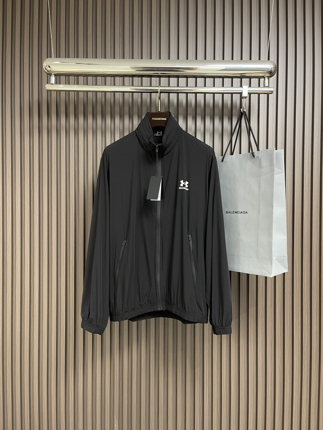 NO:504494,The balenciaga co-branded Under Armour elastic nylon jacket, the fabric is made of elastic nylon. Due to the addition of elastic fibers, it has excellent ductility and elasticity, can adapt to physical activities and have a comfortable wearing experience. Nylon has natural waterproof properties, is easy to clean and dry, and has good wrinkle resistance. The front of the jacket is decorated with LOGO and letters as the main body, which has good wear resistance and wash resistance.  The back is also decorated with an enlarged version of the dual-brand logo and letters. It highlights the fashion sense and brand recognition. The finished printed product is comparable to an art work. A hidden bag is designed under the back collar. It is opened and closed by zippers. Due to the thin and thin fabric, the hood can be hidden or opened according to different needs.  The neckline is equipped with a round beef tendon hat rope and a resin rope head to facilitate the adjustment of elasticity. The cuffs and hem are made of flat beef tendon closing, which is excellent in elasticity, making the overall clothes more lined. The hem is made of round beef tendon elastic band and hidden adjusting rope head to be both beautiful and practical. Size 46-52,,balenciaga, jackets & coats,hats,alexander wang19860909balenciaga 联名安德玛弹力尼龙夹克,面料选用弹力尼龙,由于加入了弹性纤维,使其具有出色的延展性和回弹性,能够适应身体活动并有舒适的穿着体验,尼龙有天然防水的性能,易于清洗和干燥,抗皱性能好,夹克正面饰以LOGO和字母为主体的胶浆印花,具有良好的耐磨性和耐洗性．后背同样饰以放大版的双品牌LOGO和字母.凸显了时尚感和品牌辨识度,印花成品堪比艺术作品 ,在后领下方设计了一个隐藏袋,通过拉链开合,因面料轻薄的特性,根据不同需求,可将风帽隐藏或打开．领口处设有圆牛筋帽绳搭配树脂绳头方便调节松紧度,袖口和下摆做了扁牛筋收口,弹性优良,使衣服整体更具线条感.下摆做了圆牛筋松紧带和隐藏的调节绳头既美观又实用.尺码46-52,,balenciaga,jackets & coats,hats,alexander wang,Men's clothing