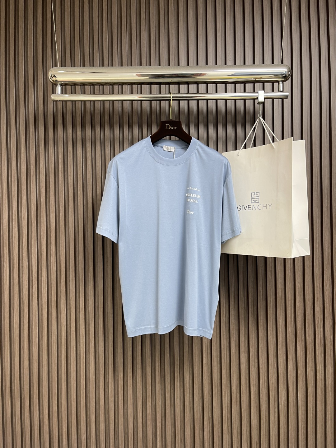 NO:518328,Dior blue couple's round neck short-sleeved T-shirt with light blue background, like a clear spring sky, pure and healing. The exquisite embroidery on the chest, 'LES FLEURS DU MAL' with Baudelaire's poetry, intertwined with the 'Dior' logo, is a romantic encounter between fashion and literature. The ratio of 99% cotton + 1% polyester fiber makes the fabric soft and skin-friendly without losing its clarity. It is comfortable and comfortable to wear on a daily basis, and can easily adapt to different scenes. The exquisite turning worker's line, from the neckline to the hem and cuffs, craftsmanship is hidden in every part, blending the sense of high-end into the details. Size XS-L,,dior,T-shirt,tees,t-shirt,alexander wang19860909Dior 蓝色情侣款圆领短袖T恤,浅蓝底色,像截取了一片春日晴空,纯净又治愈.胸前精致刺绣,'LES FLEURS DU MAL'带着波德莱尔的诗意,与'Dior'标识交织,是时尚与文学的浪漫邂逅.99％棉＋1％聚酯纤维的配比,让面料柔软亲肤又不失挺括,日常单穿舒适自在,搭配也能轻松适配不同场景.精致车工走线,从领口到下摆、袖口,每一处都藏着匠心,把高级感融进细节里.尺码XS-L,,dior,T-shirt,tees，t-shirt,alexander wang,Men's clothing