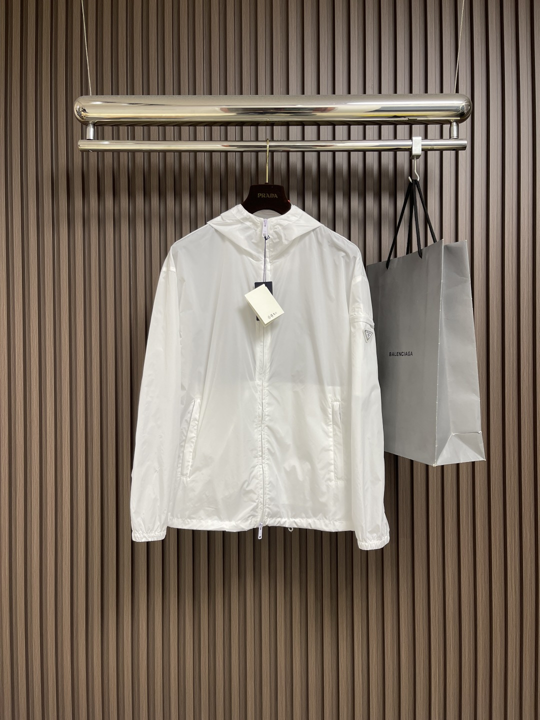 NO:520262,Prada functional zipper jacket hooded jacket, custom elegant and light and recycled nylon silk, light as feathers, comfortable skin, pure white, exudes an innate elegant temperament, neat and elegant, smooth and natural lines, complementing the pure white, the exquisite triangle logo on the side blooms the brand charm, simple but elegant, the hood flutters gently, adding a sense of agility and elegance to the overall shape, with its unique clothing and body agility switching design, becoming a model of the perfect fusion of fashion and function, custom painting templates and carving sewing lines are precisely controlled by the mockup to ensure the precise positioning of the Prada triangle mark. The fine sewing of the label and the edge of the jacket form a subtle transition, the template opens the bag, and the preset template guides the position of the bag, shape and size, and accuracy ensures the quality of the bag opening effect, and ergonomic three-dimensional cutting  Return to the traditional craftsmanship techniques through segmentation, folding, shrinking, and stretching techniques. The so-called slow work produces fine work is respect for materials and the pursuit of hand feeling. Complex workmanship, cumbersome, slow time, and high loss. Size S-XL,, prada, jackets & coats, jackets & coats, hats, alexander wang19860909Prada 功能性拉链夹克连帽外套,定制雅韵轻坚再生尼龙绸 轻盈如羽 舒适贴肤 以一袭纯净之白 散发着与生俱来的高雅气质 剪裁利落大方 线条流畅自然 与纯净的白色相得益彰 侧面那枚精致三角形徽标绽放品牌魅力 简约而不失高雅 风帽轻轻飘动 为整体造型增添了一份灵动与飘逸以其独特的服饰包体灵动切换设计 成为时尚与功能完美融合的典范之作,定制画样模版机车缝 通过画样机精确控制缝纫线路 确保Prada三角标精准定位 标签与夹克边缘的精细缝纫形成了微妙的过渡,模版机开袋 预设的模板来指导开袋的位置 形状和大小 精确性确保了开袋效果质量,人体学立体裁剪 回归传统工艺手法 通过分割 折叠 抽缩 拉展技术手法 所谓慢工出细活 是对材料的尊重 对手感的追求 做工复杂 繁琐 时效慢 损耗高.尺码S-XL,,prada,jackets & coats,jackets & coats,hats,alexander wang,Men's clothing