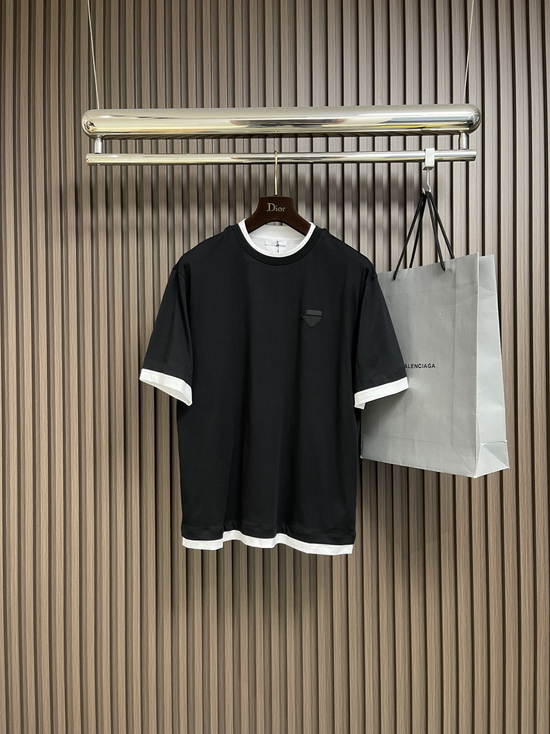 NO:525762,PRADA Fake two-piece triangle logo cotton short-sleeved T-shirt, the fabric is made of 24S double yarn special textile tight cotton 185G, ribbed 32S double yarn pull frame 340G, the classic cotton T-shirt is reinterpreted through layers and contrast, adding a unique style to the sporty silhouette. The loose style defines its style and is decorated with the iconic fabric triangle logo. The fake two-piece design successfully integrates the sporty style with the street feeling through clever layered splicing and contrasting elements, presenting a highly recognizable design language. Size XS-L, prada, T-shirt,tees, t-shirt,alexander wang19860909PRADA 假两件三角徽标棉质短袖T恤,面料采用24S双纱特种纺织紧密棉 185G,罗纹32S双纱拉架 340G,经典棉质T恤通过层次和对比重新诠释,为运动廓形增添独特风格.宽松版型定义其风格,饰有标志性织物三角形徽标.假两件设计通过巧妙的层次拼接和对比元素,成功将运动风与街头感融合,呈现出极具辨识度的设计语言.尺码XS-L,,prada,T-shirt,tees，t-shirt,alexander wang,Men's clothing