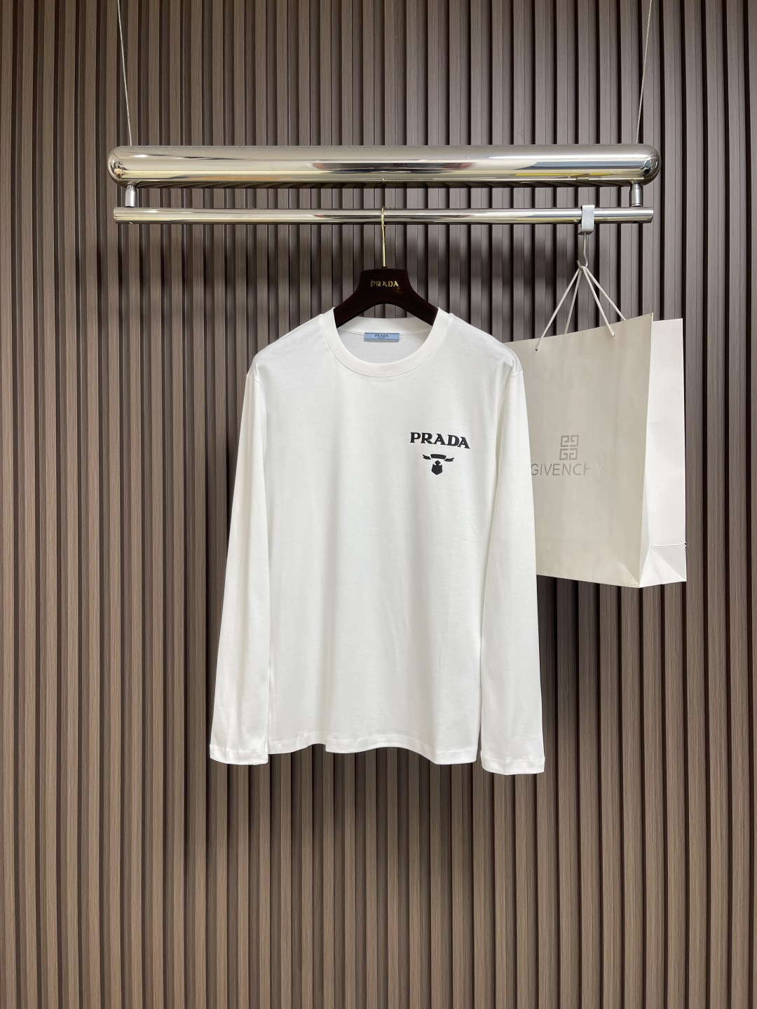 NO:572239,PRADA brand logo printed round neck long-sleeved T-shirt is made of high-quality pure cotton. It is soft and skin-friendly and has a special texture. It is smooth but has a solid thickness. It is not a cheap product that will deform when you pull it!  The letters printed on the chest are clear and three-dimensional, which instantly adds a sense of high-end, low-key yet recognizable!  The cuffs and hem are processed and hemmed very neatly, and the stitching is so even that it looks like it has been precisely calculated by a machine. It will not deform or warp no matter how many times it is washed!  The cuffs and hem are processed and rolled very neatly. They will not deform or warp even after being washed a few times. They can be matched with many types of clothing to create a fashionable look. Customized accessories, complete with three standards, same style for men and women!  Size M-3XL,,prada,tees,t-shirt,alexander wang19860909PRADA 品牌标识印花圆领长袖T恤,采用高品质纯棉,软糯亲肤还特显质感,光溜溜的但又有扎实的厚度,不是那种一扯就变形的廉价货！胸口印花字母清晰立体,瞬间把高级感拉满,低调又有辨识度！袖口和下摆的处理,卷边特别工整,缝线均匀得像机器精密计算过,水洗多少次都不会变形翘边！袖口和下摆的处理,卷边特别工整,水洗少次都不会变形翘边,能与多类型服饰搭配营造时尚造型,定制辅料,三标齐全,男女同款！尺码M-3XL,,prada,tees，t-shirt,alexander wang,Men's clothing