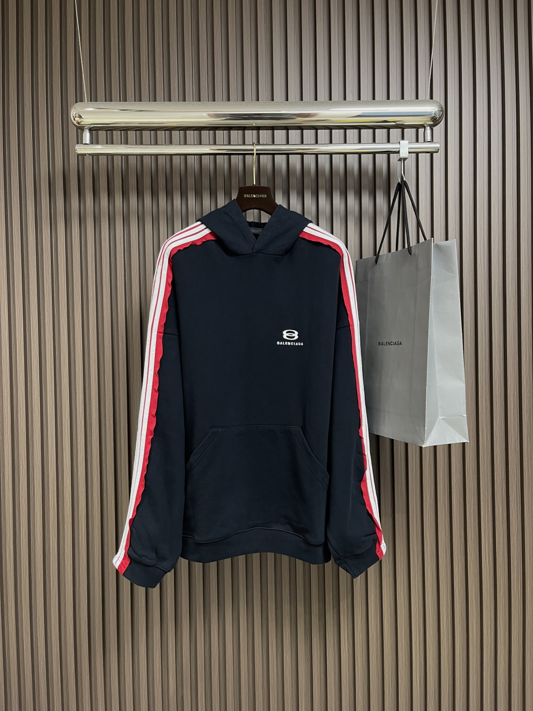 NO:573293,BALENCLAGA  The Balenciaga logo striped hooded sweatshirt is made of exclusive custom-woven 380G double-yarn cotton fabric. This customization process ensures that the fabric has the right weight and yarn structure, which is thick and warm, has a soft touch, and is stiff and not easy to deform. According to the YB process, the five-pit strip splicing through-shoulder craft ribbon is made separately and has a specific pit-strip texture.  The webbing is accurately aligned when splicing through the shoulders to ensure smooth lines on the shoulders and sleeves, enhancing the sense of three-dimensionality and layering; the logo is embroidered using a Behringer imported embroidery machine, which can accurately control the stitch length, stitch density, etc. The embroidered letter pattern is three-dimensional, full, with good gloss, fine and even stitches, high firmness and not easy to fall off!  Size 0-1-2-3,,balenciaga,balenciaga,hoodie,sweatshirts,hats,alexander wang19860909BALENCLAGA 巴黎世家标识条纹连帽卫衣,采用独家定织380G双纱棉面料,这种定制工艺确保面料有合适克重与纱线结构,既厚实保暖又有柔软触感,且挺括不易变形；根据YB工艺订做五坑条拼接通肩工艺织带,先单独制作出有特定坑条纹理的织带,通肩拼接时精准对齐,保证织带在肩部及袖子线条流畅,增强立体感与层次感；标志使用百灵达进口绣花机刺绣,这种机器能精准控制针距、线迹密度等,绣出的字母图案立体、饱满,光泽度好,针脚细密均匀,牢固度高不易脱落！尺码0-1-2-3,,balenciaga,balenciaga,hoodie,sweatshirts,hats,alexander wang,Men's clothing