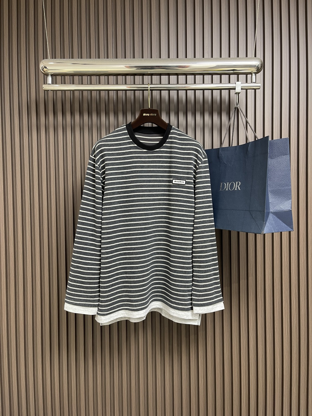 NO:530106,MiuMiu 2025SS logo logo striped long-sleeved T-shirt, 60 double-strand yarns are made of 60S 200G high-subscription combed cotton. The double-strand twisting process improves the strength of the yarn, making the fabric more delicate, crisp, wrinkle-resistant, while maintaining a soft and skin-friendly feel. The classic Jersey knitted structure provides good elasticity and drape, suitable for slim-fitting and textures on the front and back sides consistently, ensuring accurate stripe alignment. From the yarn ratio, density to gram weight, all are customized according to the original requirements to ensure color saturation and stripe clarity.  When cutting, the fabric strips must be strictly aligned at the front and rear pieces, armholes, side seams and other joints. The shoulder lines and sleeves are spliced ​​obliquely to reduce distortion; because of the extremely high requirements for grids, the fabric utilization rate may be as low as 60 (ordinary garments can reach 85), and the cost will increase significantly. Size S-XL, miumiu,tees, t-shirt, alexander wang19860909MiuMiu 2025SS 徽标logo条纹长袖T恤,定织60支双股纱线采用60S 200G高支数精梳棉,双股加捻工艺提升纱线强度,使面料更细腻、挺括、抗皱,同时保持柔软亲肤感. 平纹针织结构经典的Jersey针织提供良好的弹性和垂感,适合修身剪裁,且正反面纹理一致,确保条纹对位精准.从纱线配比、密度到克重均按原版要求定制,确保色彩饱和度和条纹清晰度. 裁片对位在裁剪时,需将面料条纹在前后片、袖窿、侧缝等接缝处严格对齐.肩线、袖笼采用斜裁拼接以减少扭曲；因对格要求极高,面料利用率可能低至60（普通成衣可达85),成本大幅上升.尺码S-XL,,miumiu,tees，t-shirt,alexander wang,Men's clothing