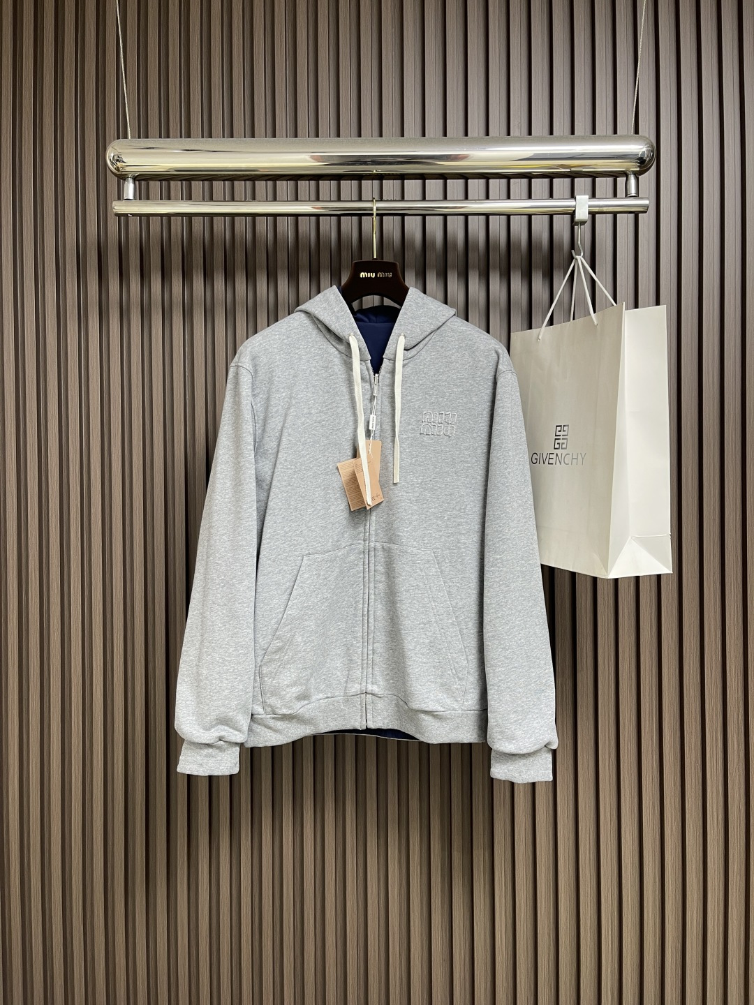 NO:529330,MIUMIU logo embroidered with double-sided hooded jacket jacket, functional poplin (Ponge) fabric is used, and the weaving method is high warp and low weft. The number of warp yarns per inch is much more than that of weft yarns. The surface is fine and uniform, diamond-shaped grain texture, which feels smooth and slightly shiny. The fiber characteristics make it natural moisture-absorbing and breathable, and it is not easy to stuffy. The high-density structure strengthens its wear resistance and has good wrinkle resistance. A single-sided fish scale fabric woven with cotton as a base has a smooth knitted surface on the front. The touching surface is formed by a three-dimensional loop through the floating thread knitting technology of the knitting machine, which increases the fluffy feeling and is also delicate. The loop structure absorbs a large amount of water and evaporates quickly, and it is not easy to deform after multiple washes.  By actively intervening in the shrinkage potential of cotton knitted surfaces, the fabric has been achieved from easy to change to stable, improving dimensional stability, and not easily deformed or wrinkled. The parts are wrapped with oblique cut cloth strips, and the width is controlled at about 0.4CM. The edges of the two layers of fabric are aligned and then folded and sewn, and the seams are hidden in the interlayer. Then they are fixed by 'anchoring points'. The inside and outside sides are formed without burrs, and all the seams are completely wrapped, while preventing the undesirable experience of easy sliding during wear. Size 46-52,,miumiu, jackets & coats, jackets & coats,hats,alexander wang19860909MIUMIU 徽标饰贴布绣双面穿连帽夹克外套,选用功能性的府绸（Ponge）面料,采用高经密,低纬密的织法,每英寸的经纱数量远多于纬纱,表面细密、均匀的菱形颗粒纹理,触感光滑且略带光泽感.纤维特性使其具有天然的吸湿透气,不易闷热.高密度的结构强化其耐磨性同时又具有良好的抗皱性.采用棉为基底编织而成的单面鱼鳞布面料,正面为平滑的针织面,触肤面通过针织机的浮线编织技术形成立体的毛圈,增加蓬松感, 同时触感细腻.毛圈结构吸水量大且蒸发快,多次洗涤不易松散变形. 通过主动干预棉针织面收缩潜能,实现了面料从易变到稳定的跨越,提升了尺寸稳定性,同时不易变形,褶皱.用斜裁布条包裹份,宽度控制在0.4CM左右.将两层面料边缘对齐后折叠缝合,缝线隐藏于夹层.再通过'锚定点'固定.形成内外两面均无毛边,所有缝份完全包裹,同时防止穿着中易滑动的不良体验.尺码46-52,,miumiu,jackets & coats,jackets & coats,hats,alexander wang,Men's clothing