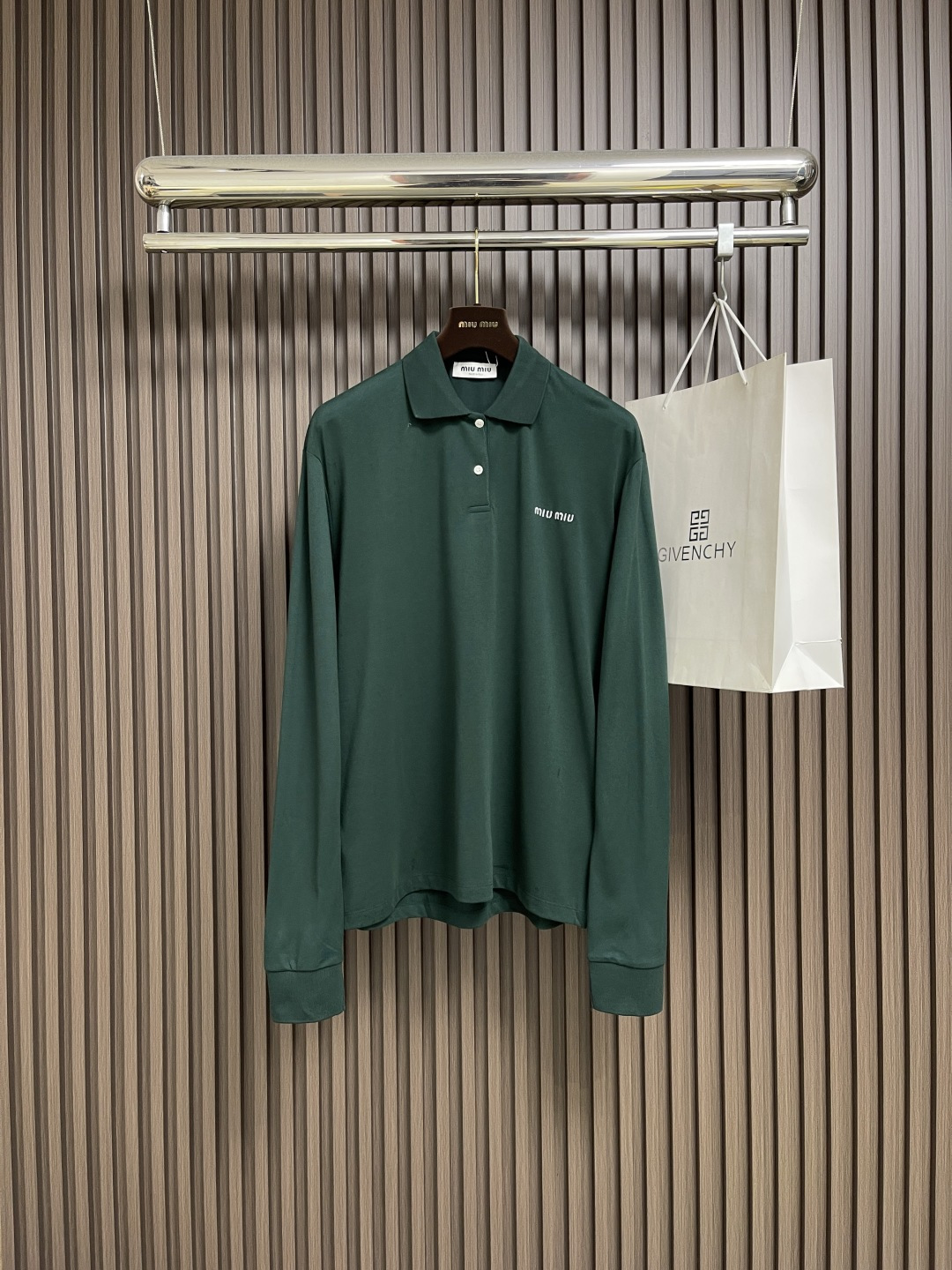 NO:540676,MIUMIU letter embroidered lapel long-sleeved POLO, uses high-quality beaded fabric, with a sparse surface, similar to a honeycomb, providing excellent breathability and moisture permeability, making it more dry and comfortable when worn. The hardness of the fabric makes the styling of the lo shirt more three-dimensional and suitable for making lapel shirts. Oversize design, combined with the classic lo shirt collar and button front closure, shows a casual but formal style. The long-sleeved design and side slits, plus the double-head crochet bottom edge enhance the durability and comfort of the clothing. In addition, the detailed treatment of the embroidered logo not only adds iconic, but also highlights the exquisite craftsmanship of the brand. This lo shirt is a perfect combination of Miu Miu's fashionable personality and classic. Size S-M-L,,miumiu,versace,alexander wang19860909MIUMIU 字母刺绣翻领长袖POLO,采用高品质珠地面料,其表面呈疏孔状,类似蜂巢,提供卓越的透气性和透湿性,穿着时更加干爽舒适.面料的硬挺特性使得lo衫的版型更加立体,适合制作翻领衫.Oversize版型设计,结合经典的lo衫领和纽扣前襟,展现出休闲而不失正式的风格.长袖设计和侧边开衩,加上双头钩针底边,增强了服装的耐用性和舒适度.此外,刺绣徽标的细节处理,不仅增添了标志性,也彰显了品牌的精致工艺.这款lo衫是Miu Miu时尚个性与经典的完美结合.尺码S-M-L,,miumiu,versace,alexander wang,Men's clothing