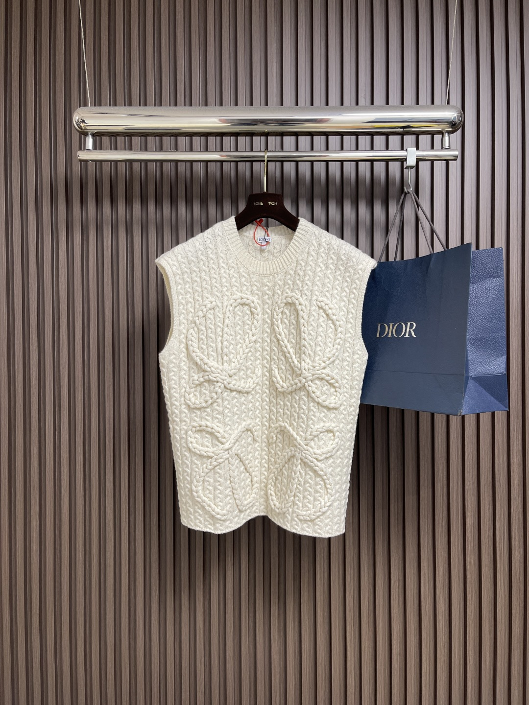 NO:548523,Loewe Anagram twist knitted sleeveless vest sweater, custom-woven heavyweight mercerized wool embossed knitted wool, full of texture, thick and solid, with dark black as the background color, hand-operated special machine embossed pattern technology, customized special knitting machine manually controlled by craftsmen, human-machine collaborative knitting logic, real-time adjustment of yarn tension to control the rise and fall of knitting needles, forming a Loewe Anagram pattern with three-dimensional concave and convex texture, full range twisted rope composite dual process  The symphonic weaving art of hand and machine. The entire garment is woven with twisted rope + webbing. It is manually connected row by row. Each knitting row needs to complete the three steps of twisting the rope, inserting the webbing and resetting the needle bed. Weaving a garment requires a total of 200-300 rows (time-consuming and labor-intensive).   Expensive labor) Sizes S-XL,,loewe,loewe,sweaters,alexander wang19860909Loewe 罗意威 Anagram 麻花编织无袖马甲毛衣,定织重磅丝光羊毛浮雕针织毛料 质感十足 厚重扎实 以玄黑为底色 手摇专机浮雕花型工艺 通过匠人手工操控定制化专用编织机 人机协同的编织逻辑 实时调整纱线张力控制织针起落 形成具有立体凹凸肌理的Loewe Anagram花型图案 全域扭绳复合双工艺 手工与机械的交响织艺 整件服饰均采用扭绳＋织带复合编织 逐行手工衔接 每编织1行需完成扭绳缠绕一织带穿插一针床复位3个步骤 编织一件成衣需累计200-300行（耗时耗力 工价昂贵）尺码S-XL,,loewe,loewe,sweaters,alexander wang,Men's clothing