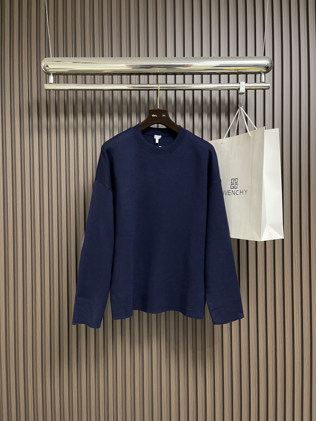 NO:538616,LOEWE The 3D embroidered round neck sweater is made of wool-blend fabric, mainly composed of 96% wool, combining 3% nylon and 1% spandex. The wool body ensures the warmth and comfort of the clothes. The addition of a small amount of nylon and spandex significantly improves the elasticity and wear resistance. The ribbed decorative parts use wool to further enhance the texture and wear experience. The fabric and cushion material are tightly fixed on the frame of the embroidery machine. The embroidery machine uses sparse stitches along the plate mark of the padding layer to outline the filling area of ​​the pattern, and then runs the plate mark of the covering layer, and perfectly cover the foam with dense stitches. Above the padding layer, a slightly raised Anagram embroidery is formed. The touch is soft and full. The thick thread layer plays a protective role, greatly improving its wear resistance. Add detergent and initially rinse the large goods at a water temperature of about 35 degrees to remove impurities in the production process. Then gently digest the feathers on the surface through protease, reduce the tendency to pill from the root, improve the feel, retain the softness, and eliminate the stimulation. Finally, after dehydration and drying, the size and shape stability are improved. Size S-XL, loewe, sweaters, alexander wang19860909LOEWE 垫衬3D刺绣圆领毛衣,采用了羊毛混纺面料,以96％的羊毛为主,结合了3％的锦纶和1％的氨纶,羊毛主体保证了衣物的保暖性和舒适度,少量锦纶与氨纶的加入使弹性和耐磨性得到显著提升.罗纹装饰部件则选用了羊毛,进一步提升了质感与穿着体验.将面料和垫衬材料一同紧绷地固定在绣花机框架上,绣花机沿着垫衬层的版迹运用较稀疏的针迹勾勒出图案的填充区域,紧接着运行覆盖层的版迹,用密集的针迹完美地覆盖在泡沫垫衬层之上,从而形成微凸起的Anagram刺绣,触感柔软且饱满,厚厚的线层起到了保护作用,使其耐磨性大大提升,加入洗涤剂,将大货在约35度的水温下进行初步漂洗,去除生产过程中的杂质,再通过蛋白酶温和的消化掉表面的毛羽,从根源上减少起球倾向,改善手感,保留柔软度,消除刺激感.最后通过脱水和烘干处理之后,提升尺寸和形状稳定性.尺码S-XL,,loewe,sweaters,alexander wang,Men's clothing