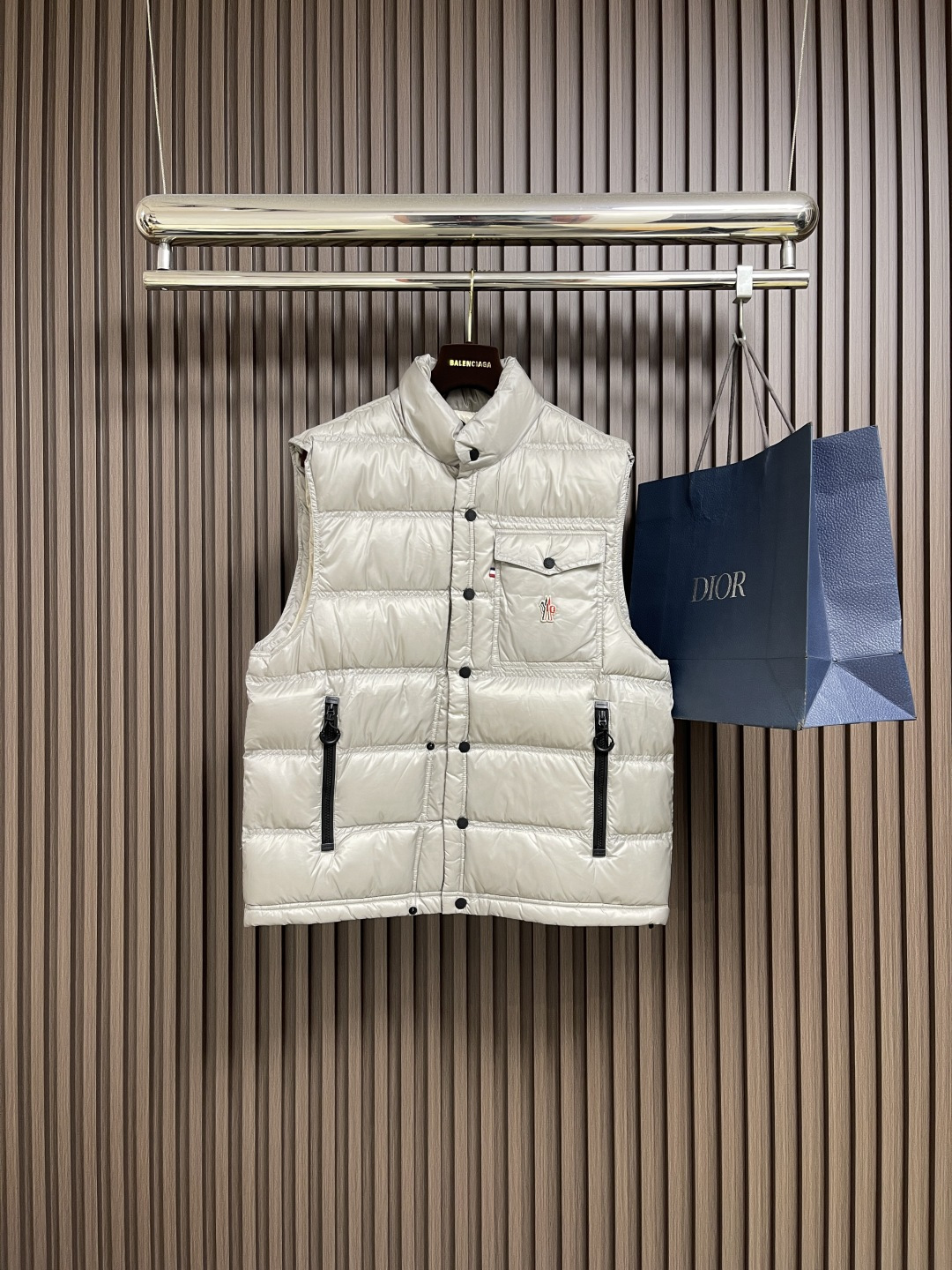 NO:540706,Moncler The reflective down vest is made of extremely fine nylon yarns and is knitted in a high density manner. There are many yarns per unit area, and the gaps between the yarns are very small, which can effectively block the penetration of cold air. The fine weaving method keeps it lightweight and soft, and in terms of physical structure, it limits the light down fibers to drill out of the gaps. The nylon fiber itself has good wear resistance and is not easy to hook, which significantly improves the service life and easily cope with multiple scenarios. The lid made of high-density woven with polyester fibers is 0.08mm thick to avoid increasing the overall Weight and smooth, high-density braided structure forms an air resistance layer, protecting the thermal efficiency of the warm-keeping layer from loss, and can withstand down expansion pressure to prevent deformation and damage after long-term use. 90 white duck down is selected, with a weight of 130g, ensuring excellent warm-keeping performance. After strict screening and processing of the velvet, it is not easy to drill velvet, ensuring durability. The logo is arranged in regular arrangement of dozens of small holes on the triangular reflector through the reflective cloth punching process, which improves functionality and enhances recognition and aesthetics. Size 1-2-3-4,,down Jacket,alexander wang19860909Moncler 饰反光标羽绒马甲,选用极细锦纶纱线通过高密度的方式编织而成,单位面积内的纱线数量多,纱线之间的空隙非常小,能有效阻隔冷风穿透.细密的编织法使其保持轻量化和柔软的触感,在物理结构上限制了轻盈的羽绒纤维从缝隙中钻出.锦纶纤维本身拥有良好的耐磨性,不易勾丝,显著提升了使用年限,轻松应对多场景需求,采用聚酯纤维高密编织而成的里布,0.08mm厚度避免增加整体重量且穿着顺滑,高密编织结构形成风阻层,保护保暖层热效率不流失,同时可承受羽绒膨胀压力,防止长期使用后变形破损.选用90白鸭绒,克重达130g,确保保暖性能卓越.绒子经过严格筛选与处理之后,不易钻绒,保证了耐用性.通过反光布冲孔工艺将Logo以数十个小孔规则排列呈现在三角形反光标之上,提升功能性的同时强化了辨识度和美观性.尺码1-2-3-4,,down jacket,alexander wang,Men's clothing