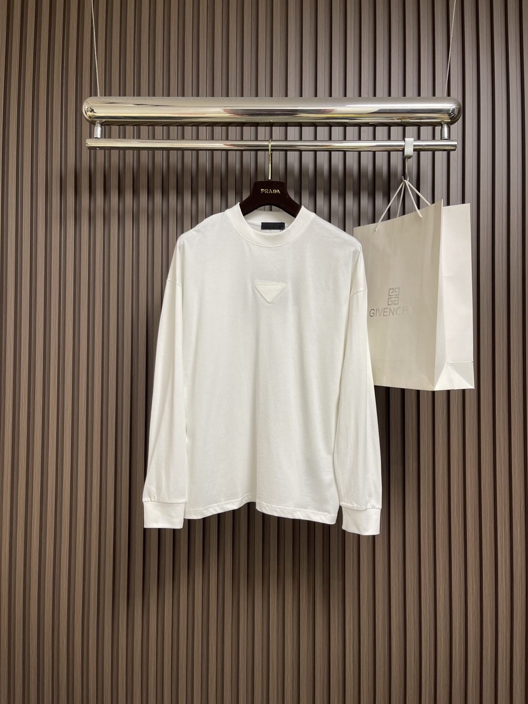 NO:563656,PRADA Triangle Logo Round Neck Long Sleeve T-shirt is made of high-quality pure cotton, which is soft and skin-friendly and has a unique texture. It is smooth but has a solid thickness, low-key yet recognizable!  The cuffs and hem are processed and hemmed very neatly, and the stitching is so even that it looks like it has been precisely calculated by a machine. It will not deform or warp no matter how many times it is washed!  The cuffs and hem are processed and rolled very neatly. They will not deform or warp even after being washed a few times. They can be matched with many types of clothing to create a fashionable look. Customized accessories, complete with three standards, same style for men and women!  Size M-3XL,,prada,tees,t-shirt,alexander wang19860909PRADA 三角标识标识圆领长袖T恤,采用高品质纯棉,软糯亲肤还特显质感,光溜溜的但又有扎实的厚度,低调又有辨识度！袖口和下摆的处理,卷边特别工整,缝线均匀得像机器精密计算过,水洗多少次都不会变形翘边！袖口和下摆的处理,卷边特别工整,水洗少次都不会变形翘边,能与多类型服饰搭配营造时尚造型,定制辅料,三标齐全,男女同款！尺码M-3XL,,prada,tees，t-shirt,alexander wang,Men's clothing