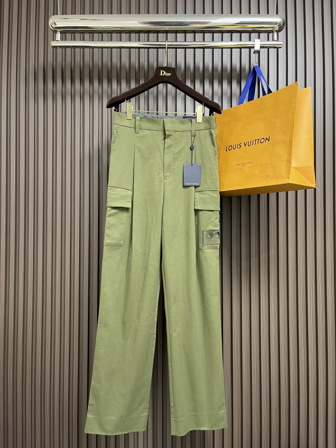 NO:563699,LV   The Nigo co-branded series of 3D portrait pocket overalls is made of twill blended cotton to create a classic design that can easily fit into various styles. The embroidered portrait patch on the left highlights the collaboration logo, the neat pleats deconstruct the front silhouette, and the flap pockets highlight the functional style. Classic  After special processing, the twill blended cotton fabric retains the breathable and wear-resistant properties of pure cotton, while injecting elasticity through spandex; the upper body is crisp and stylish but moves freely, completely bidding farewell to the stiffness of traditional workwear. The exquisite portrait embroidery patch on the left is highly recognizable; the three-dimensional flip  The flap pockets and deconstructed pleat design take into account both functional style and high-end fashion. Whether paired with a pair or a pair, it can instantly enhance the overall look. With its classic workwear silhouette and co-branded design elements, the standard version is easy to control; it can be easily matched with everything from, to, etc., and is a perfect fit  A variety of styling needs. It not only retains the inherent rugged functional style, but also injects exquisite embellishments through deconstructed pleats and co-branded embroidery. It is an iconic item that is both daily practical and brand topical. Sizes 44-46-48-50, Louis   vuitton,alexander wang19860909LV Nigo联名系列3D人像口袋工装裤,以斜纹混纺棉布塑造经典设计,可轻松契合各式造型.左侧刺绣肖像贴饰点明的携手合作标识,齐整褶祠解构正面廓形,翻盖口袋彰显机能风范.经典斜纹混纺棉布特殊加工处理后,既保留了纯棉的透气耐磨特性,又通过氨纶注入弹性；上身挺括有型却活动自如,彻底告别传统工装的僵硬感.左侧精致的肖像刺绣贴饰,辨识度极高；立体翻盖口袋与解构褶裥设计,兼顾机能风与高级时装感.无论是搭配还是,都能瞬间提升整体造型层次.其经典工装廓形和联名设计元素,标准版型易于驾驭；能轻松搭配从、到等各式,完美契合多种造型需求.它既保留了固有的粗犷机能风范,又通过解构褶祠和联名刺绣注入了精致点缀,是一款兼具日常实穿性与品牌话题性的标志性单品.尺码44-46-48-50,,louis vuitton,alexander wang,Men's clothing